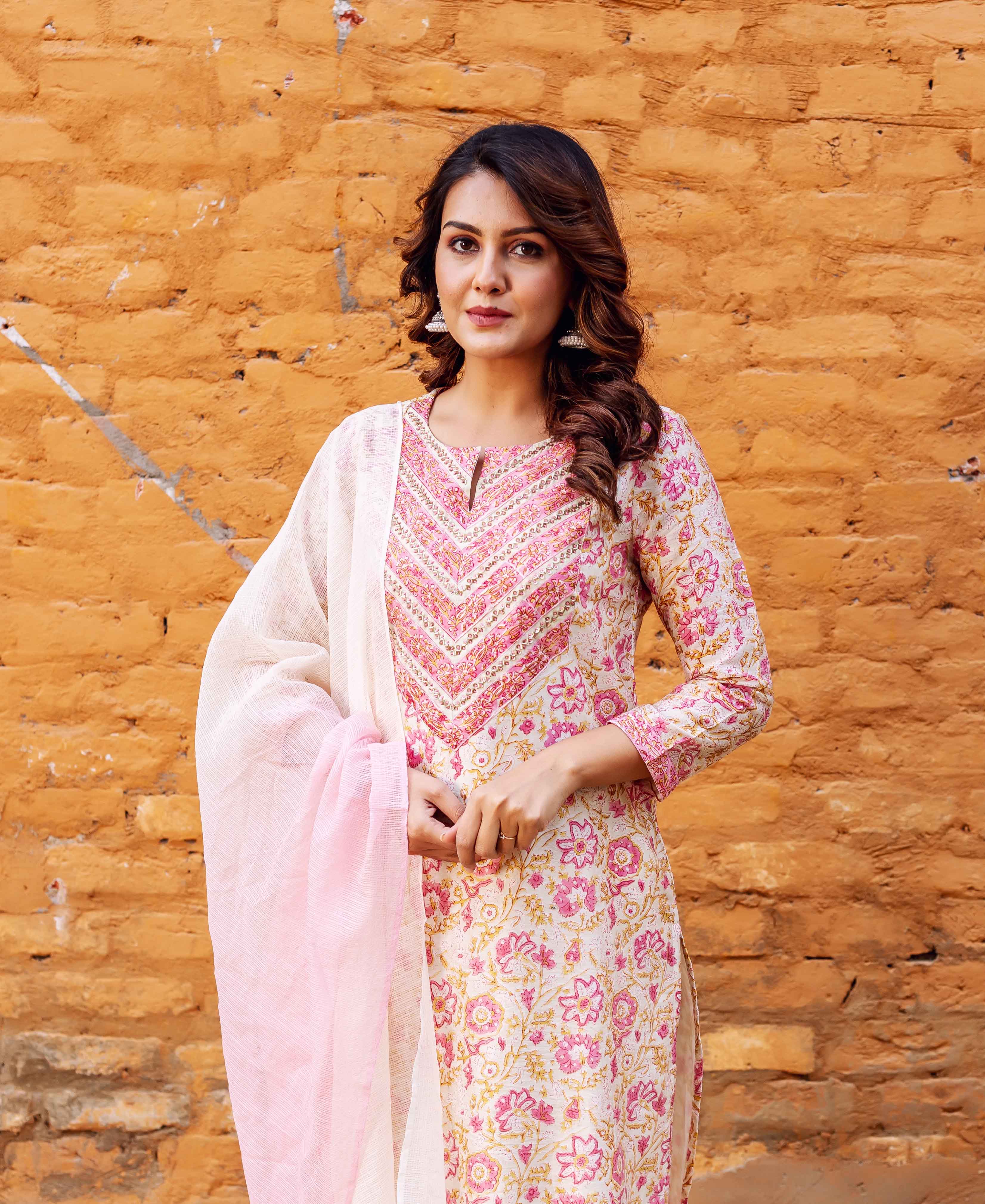 Model in front, cream and pink block printed kurta with geometric yoke, light dupatta.