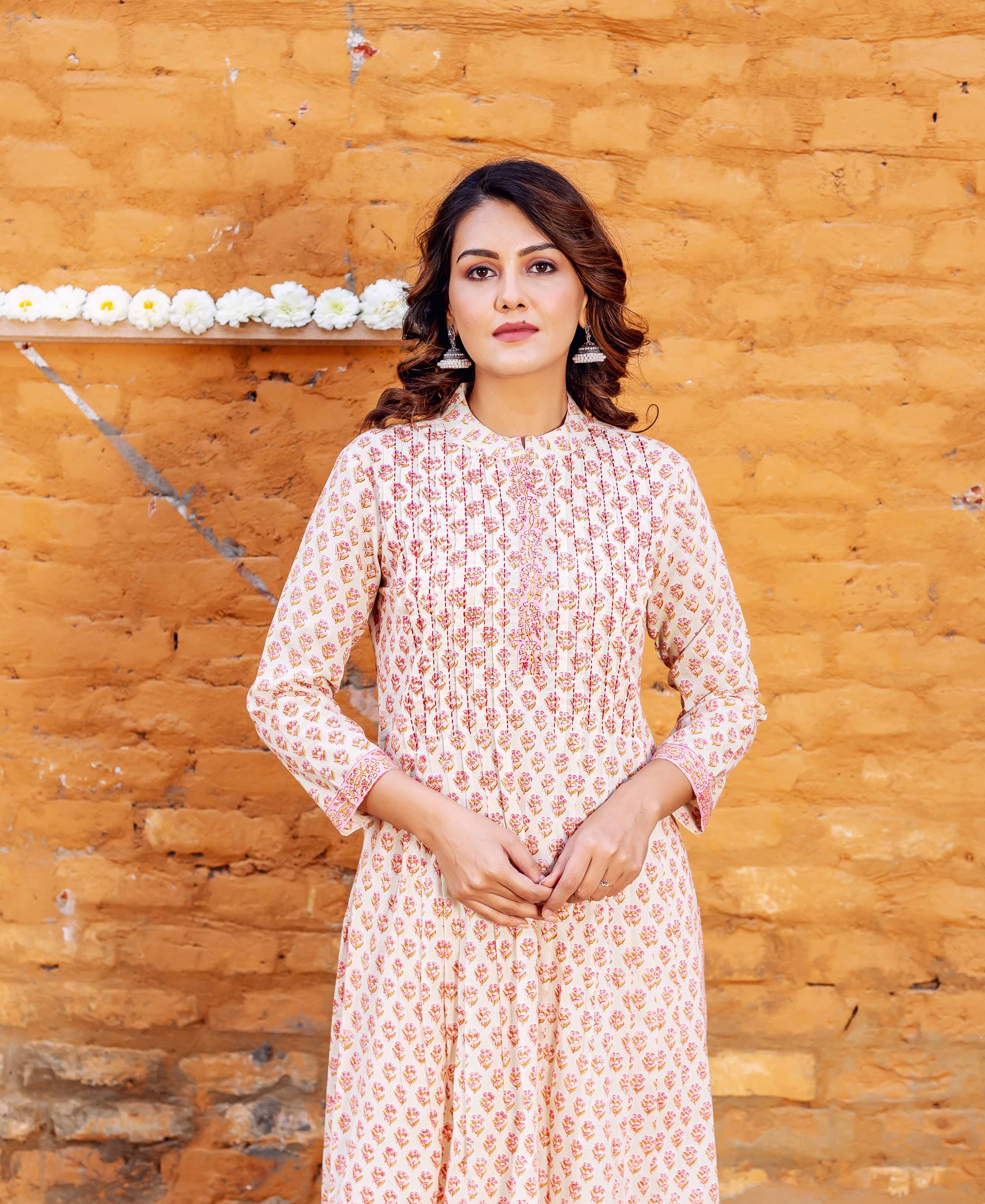 Front view of model in cream block-printed straight cotton kurta with pink leaf motifs.