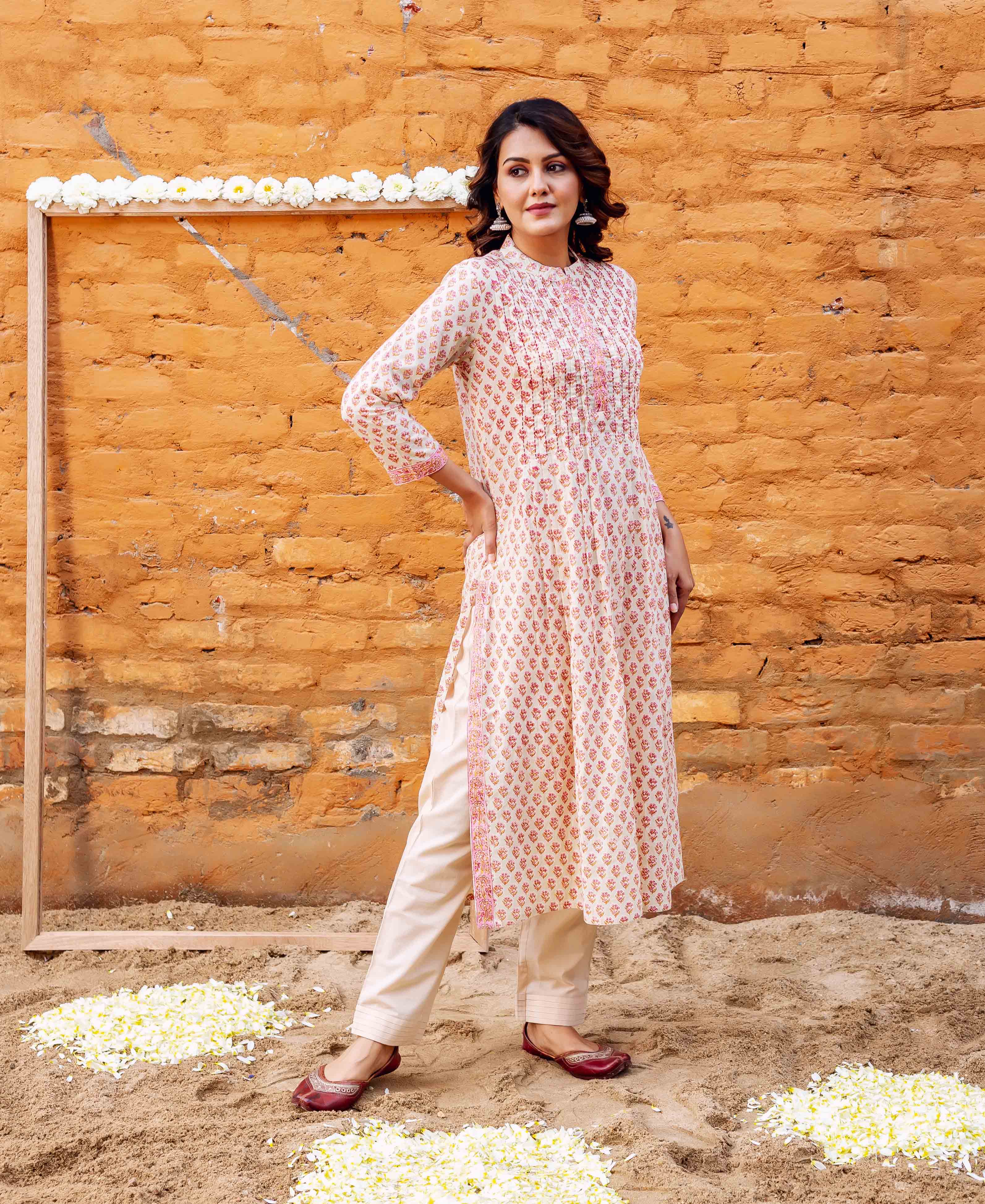 Full-length woman in off-white block-printed straight cotton kurta, cream pants, and maroon juttis.
