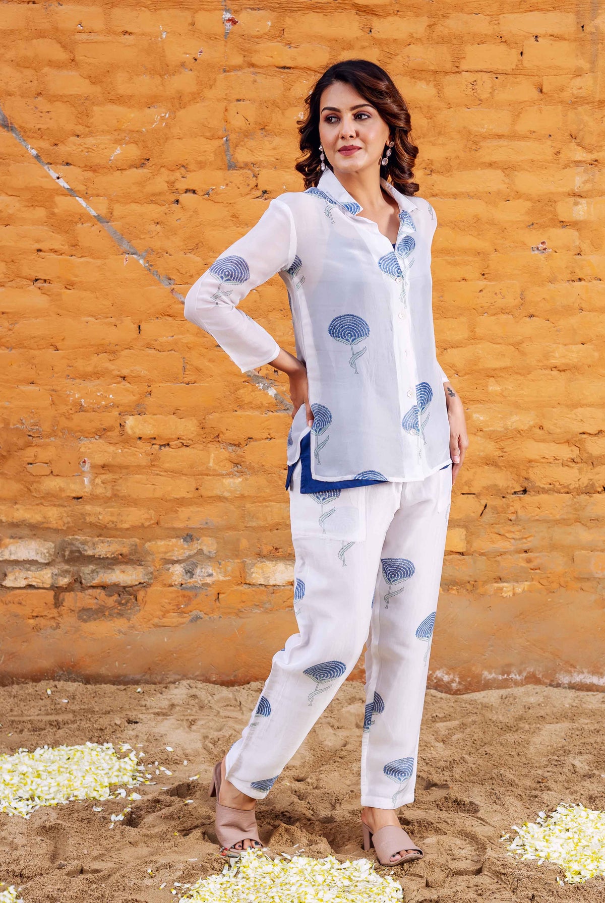 Front view of woman in white hand-block-printed blue floral co-ord set, shirt and pants.