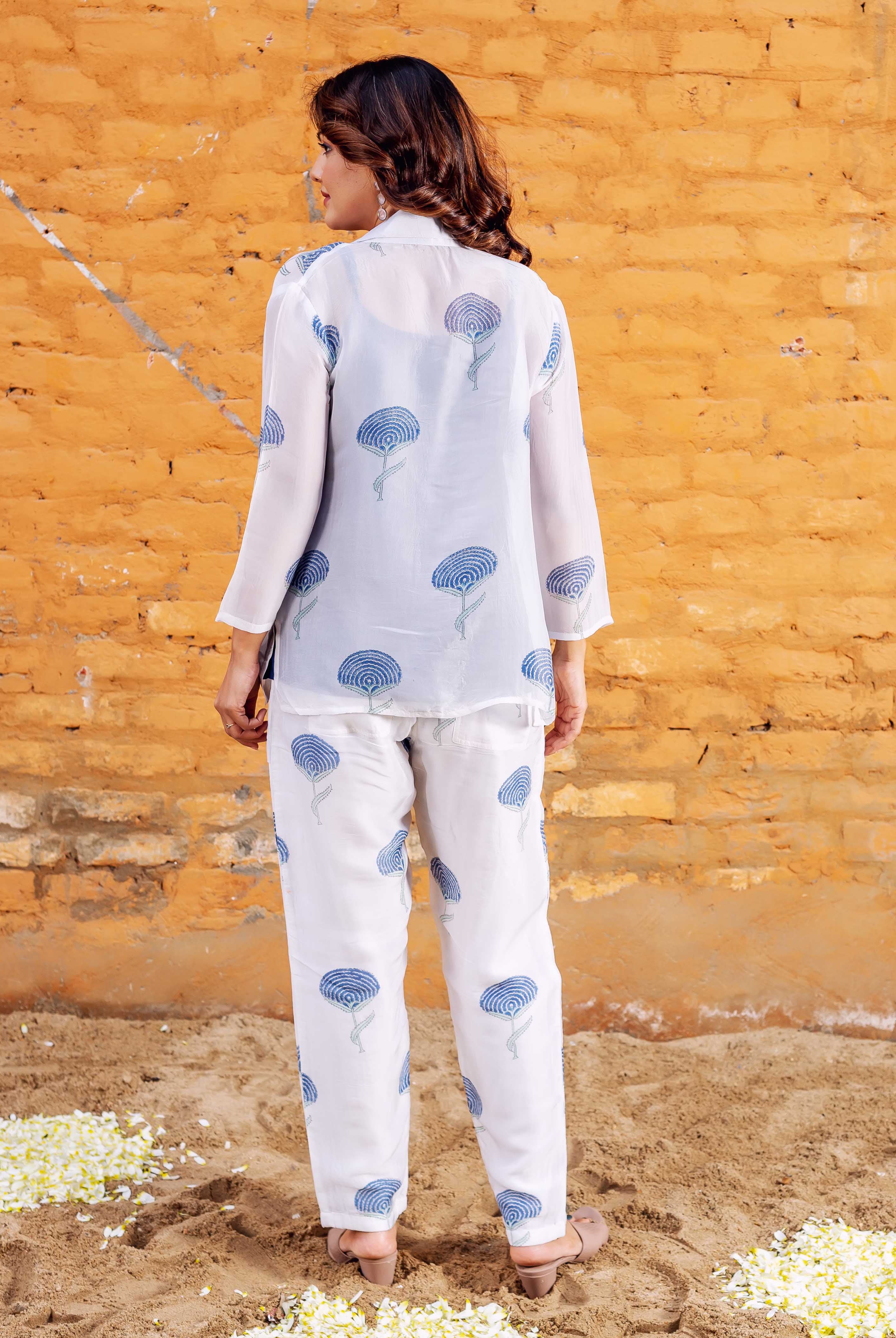 Back view of model in white co-ord set with blue hand-block-printed floral pattern.