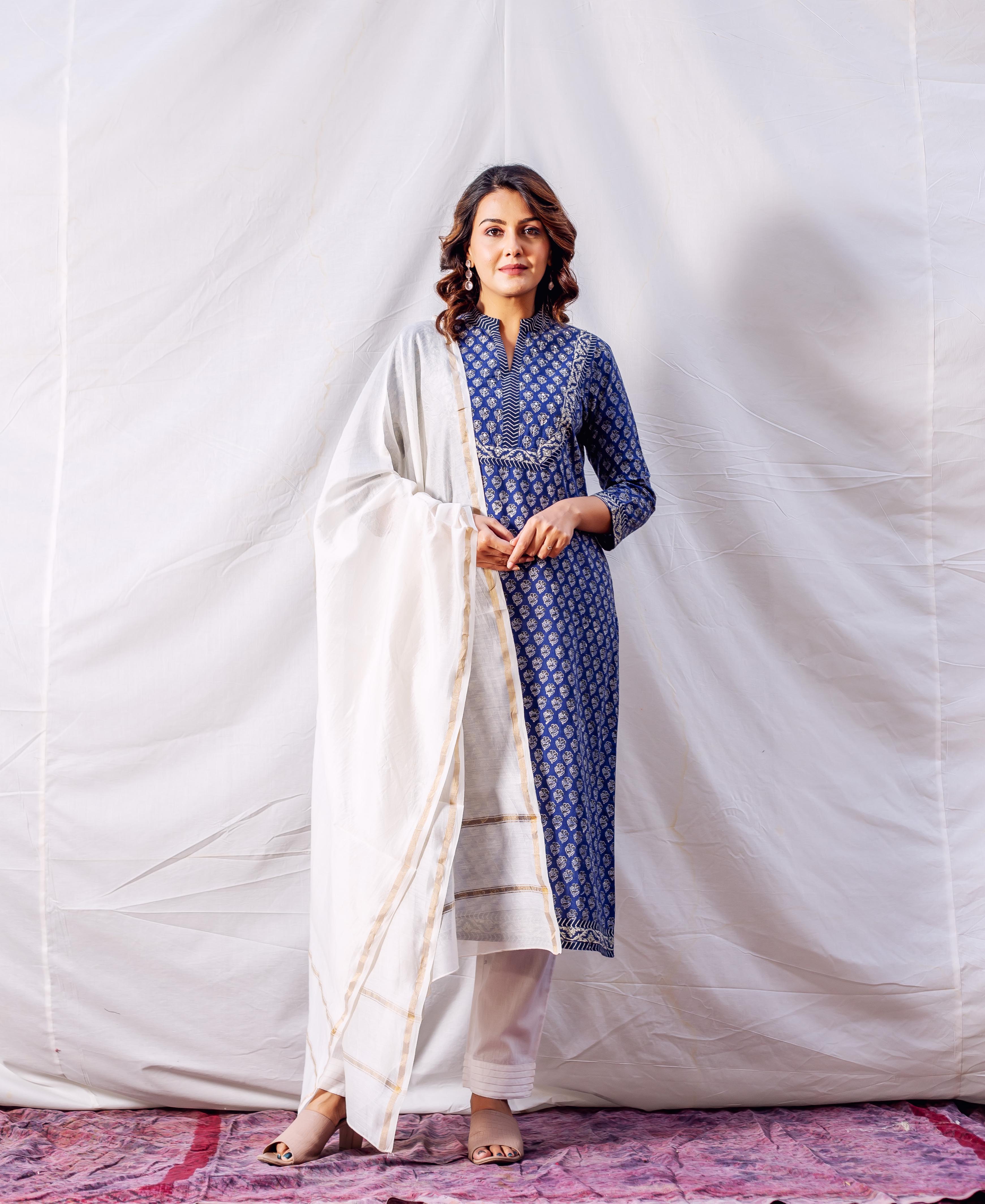 Woman in blue hand-block-printed and embroidered kurta, white pants, and white dupatta.
