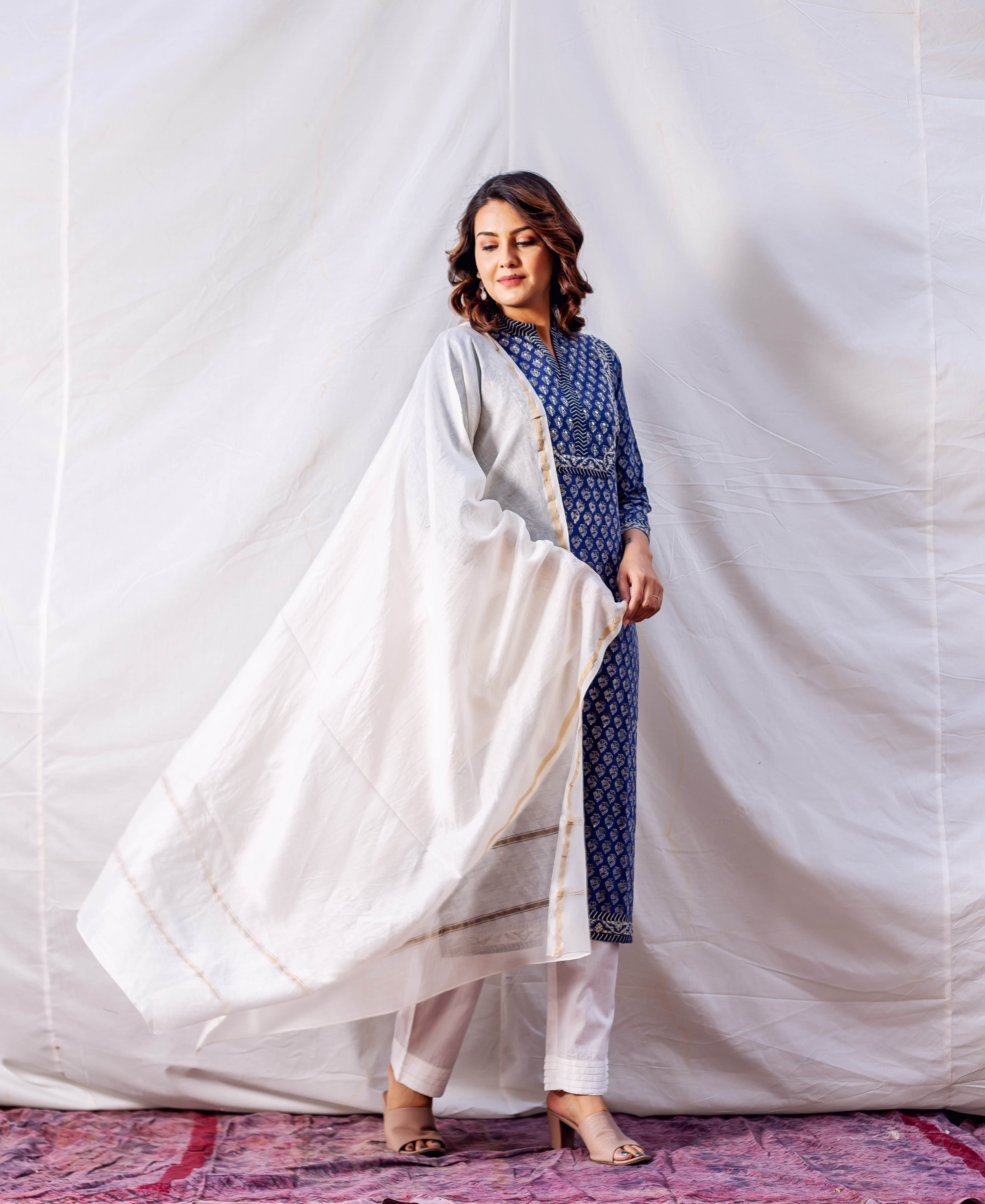 Woman in indigo hand block printed & embroidered straight kurta with white dupatta.