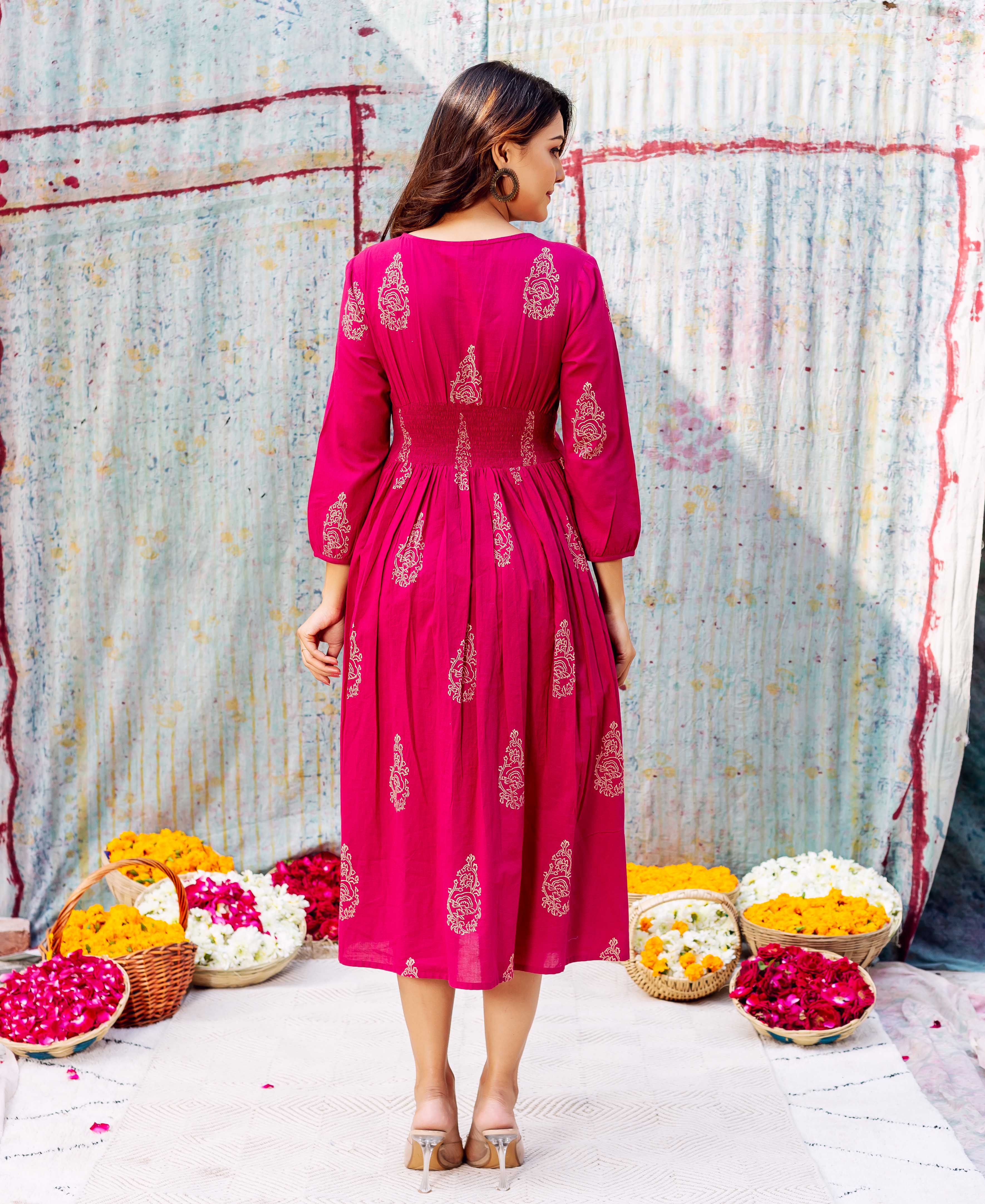 Model's back in vibrant fuchsia ethnic midi dress with gold-toned hand-block print.