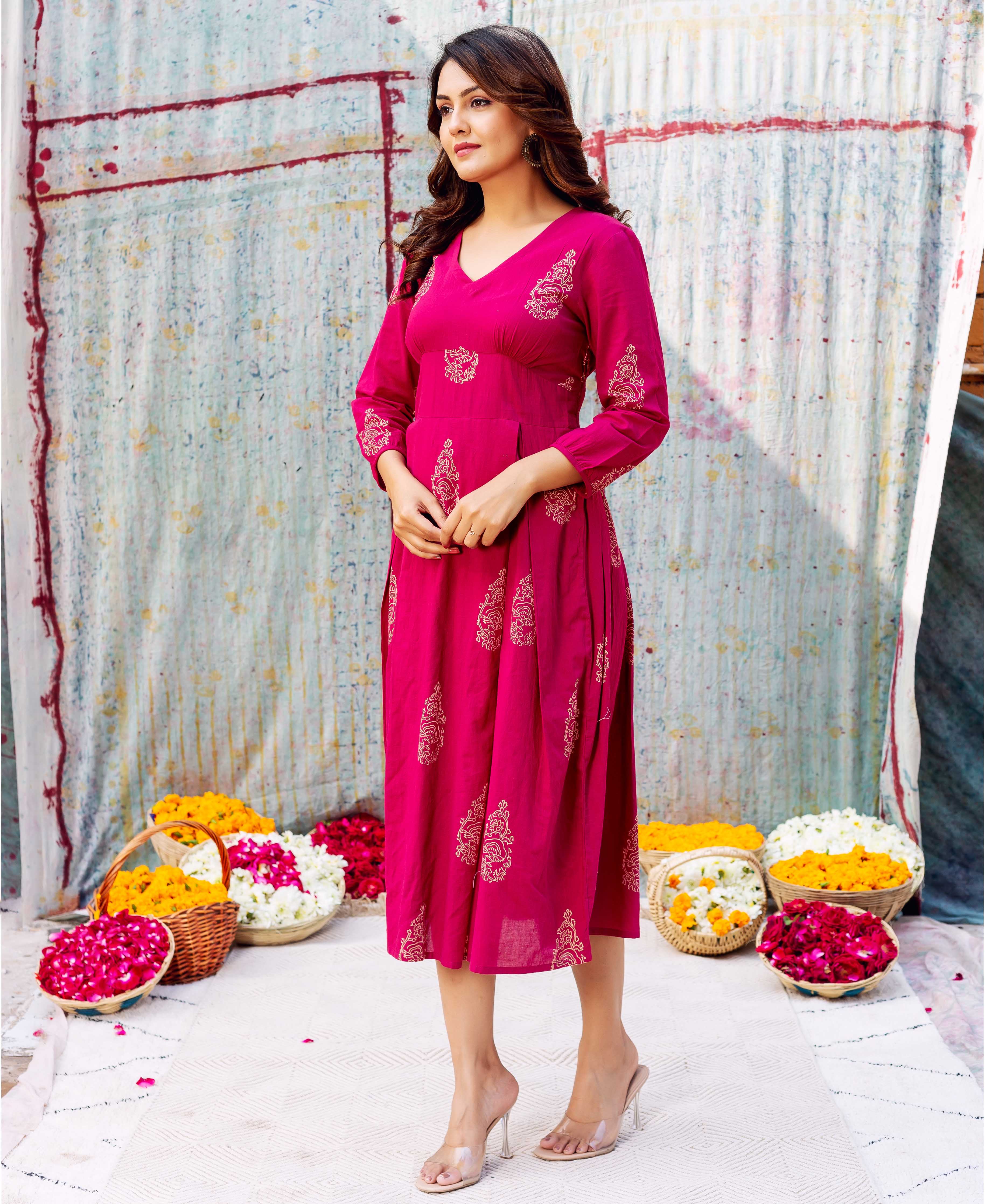 Model wearing a vibrant fuchsia V-neck dress with golden ethnic hand-block prints.