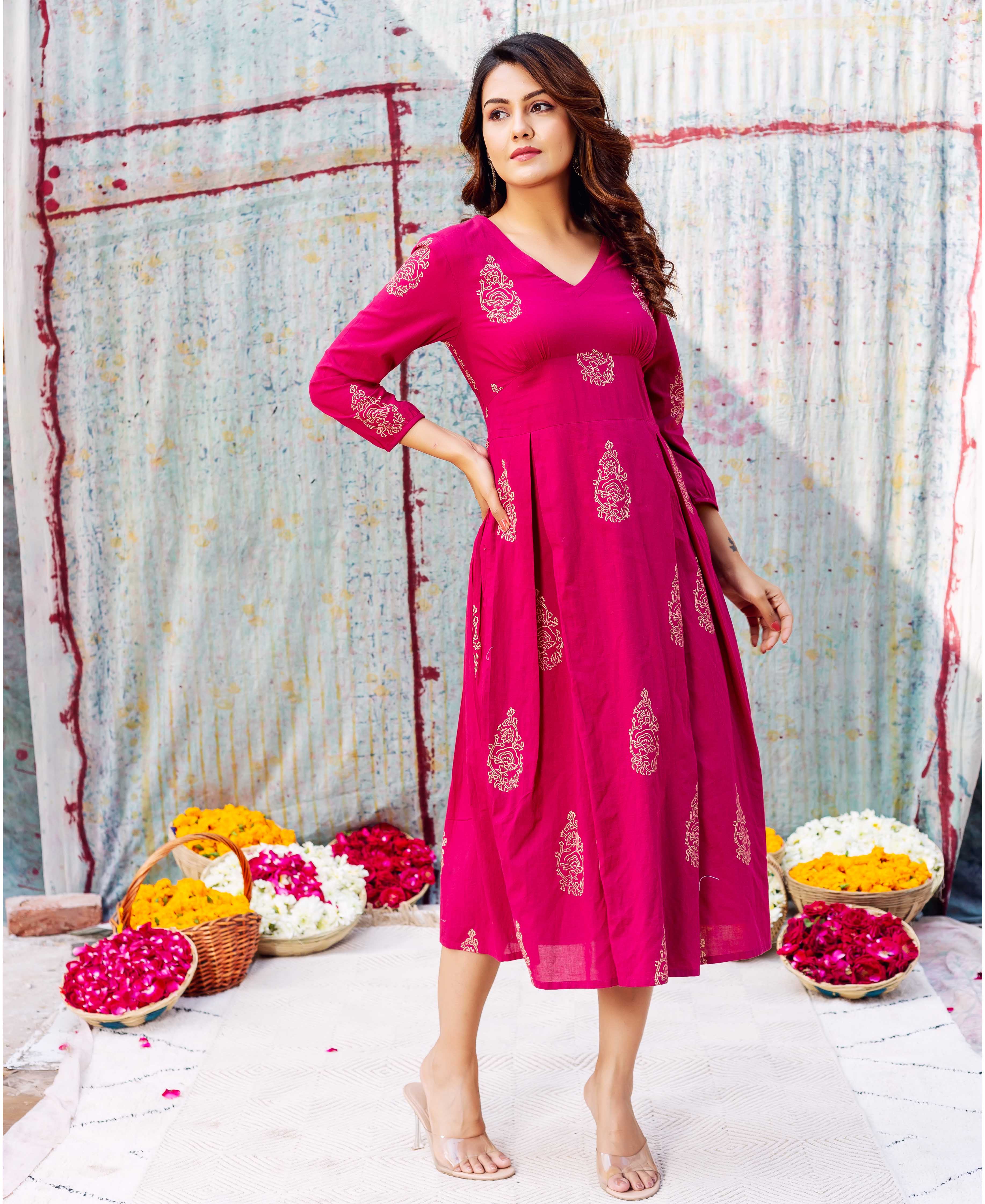 Model wearing a vibrant fuchsia Stella dress featuring gold hand-block printed ethnic patterns.