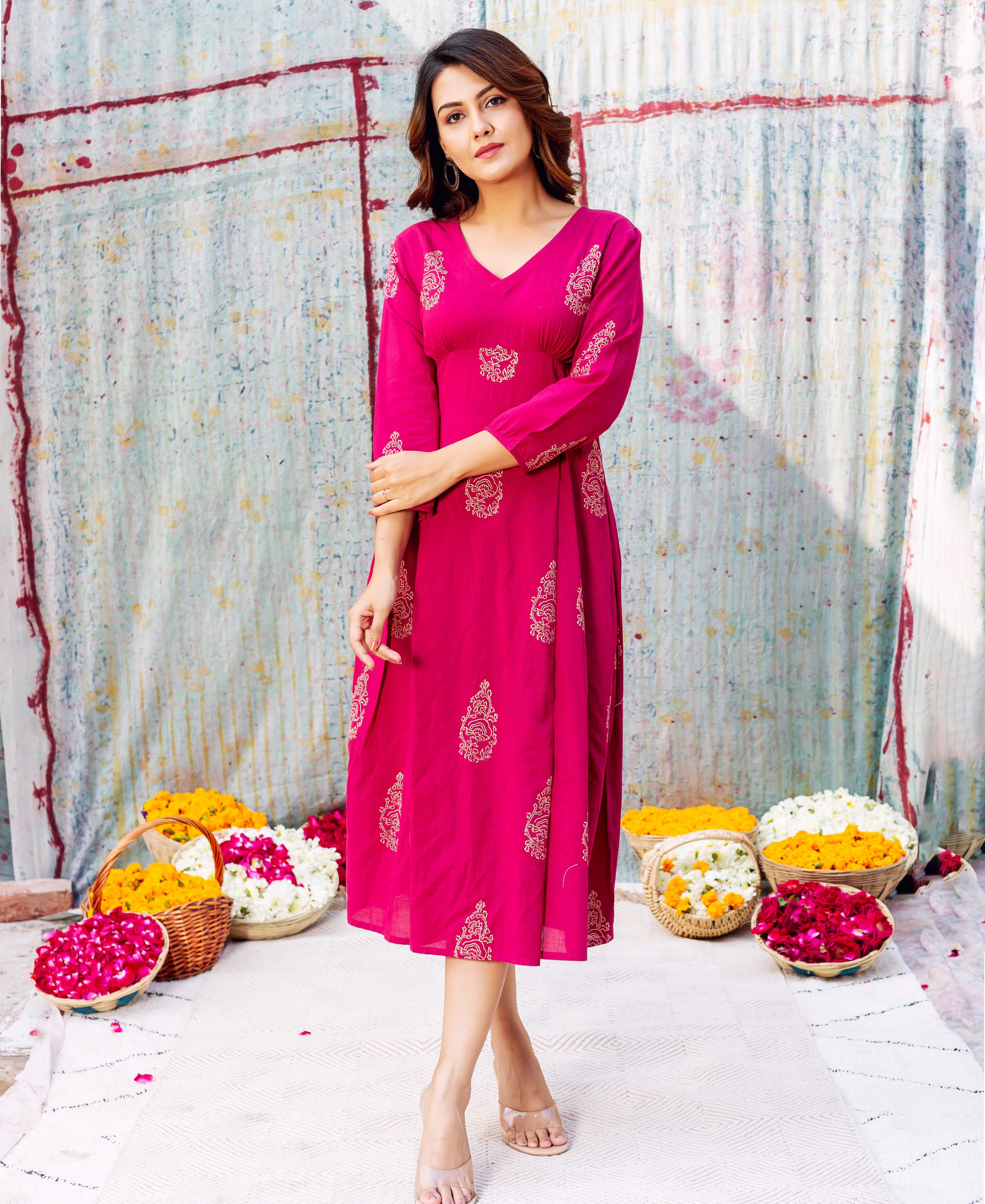 Full-length model wearing a hot pink V-neck hand-block-printed ethnic dress with gold patterns.