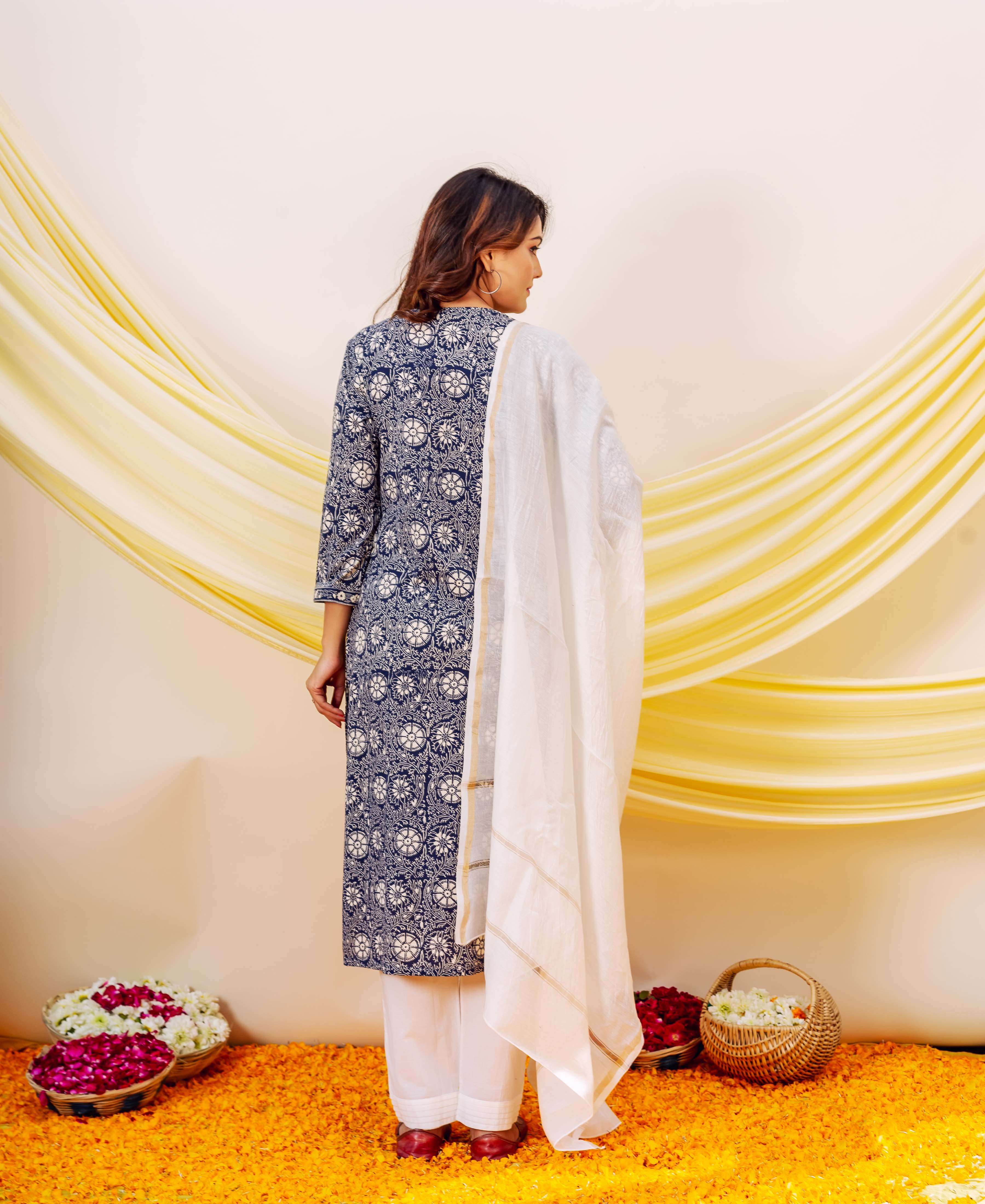 Full back view of model in indigo hand-block-printed kurta set with white dupatta.
