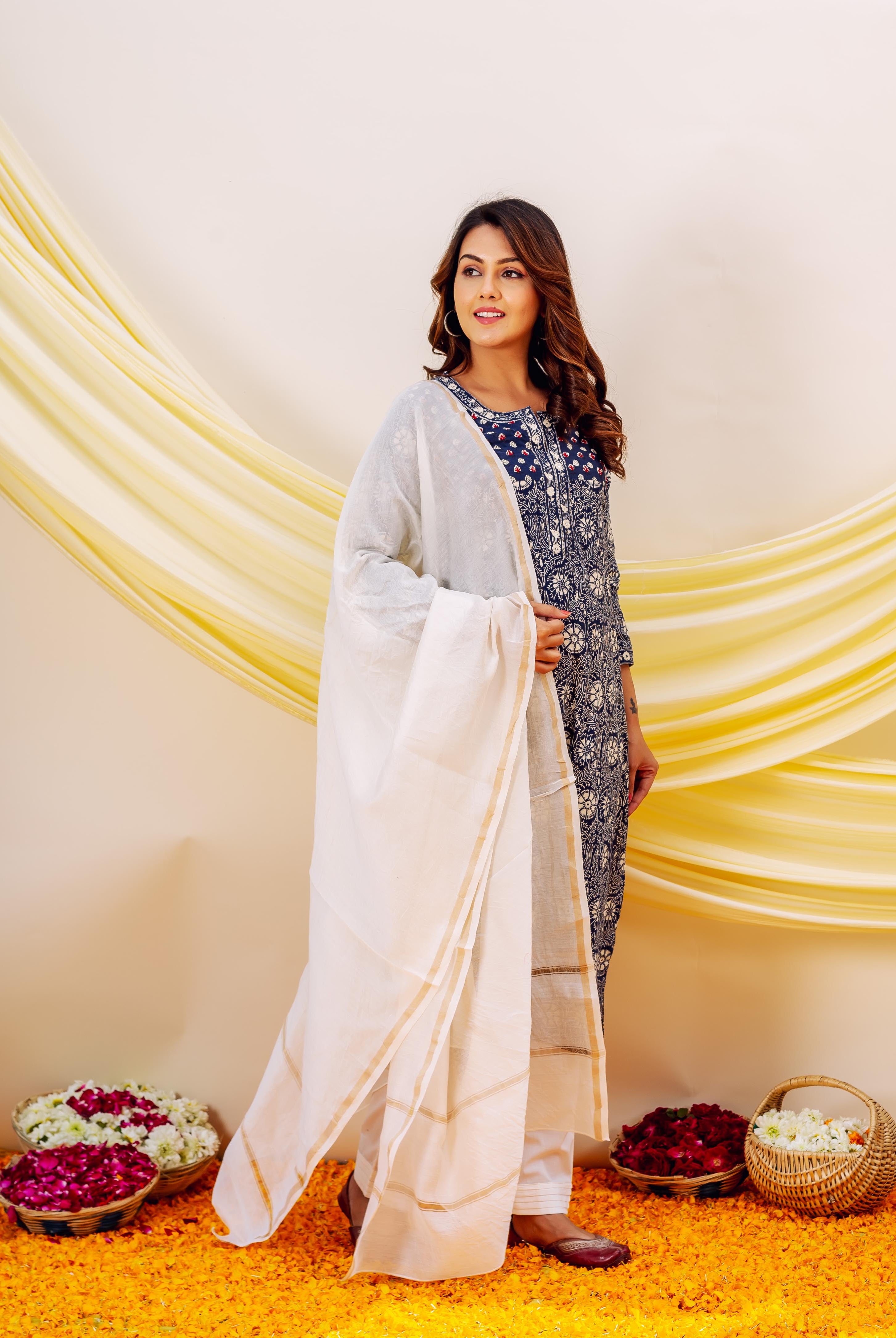 Model in indigo hand-block-printed kurta set with white dupatta and golden border.