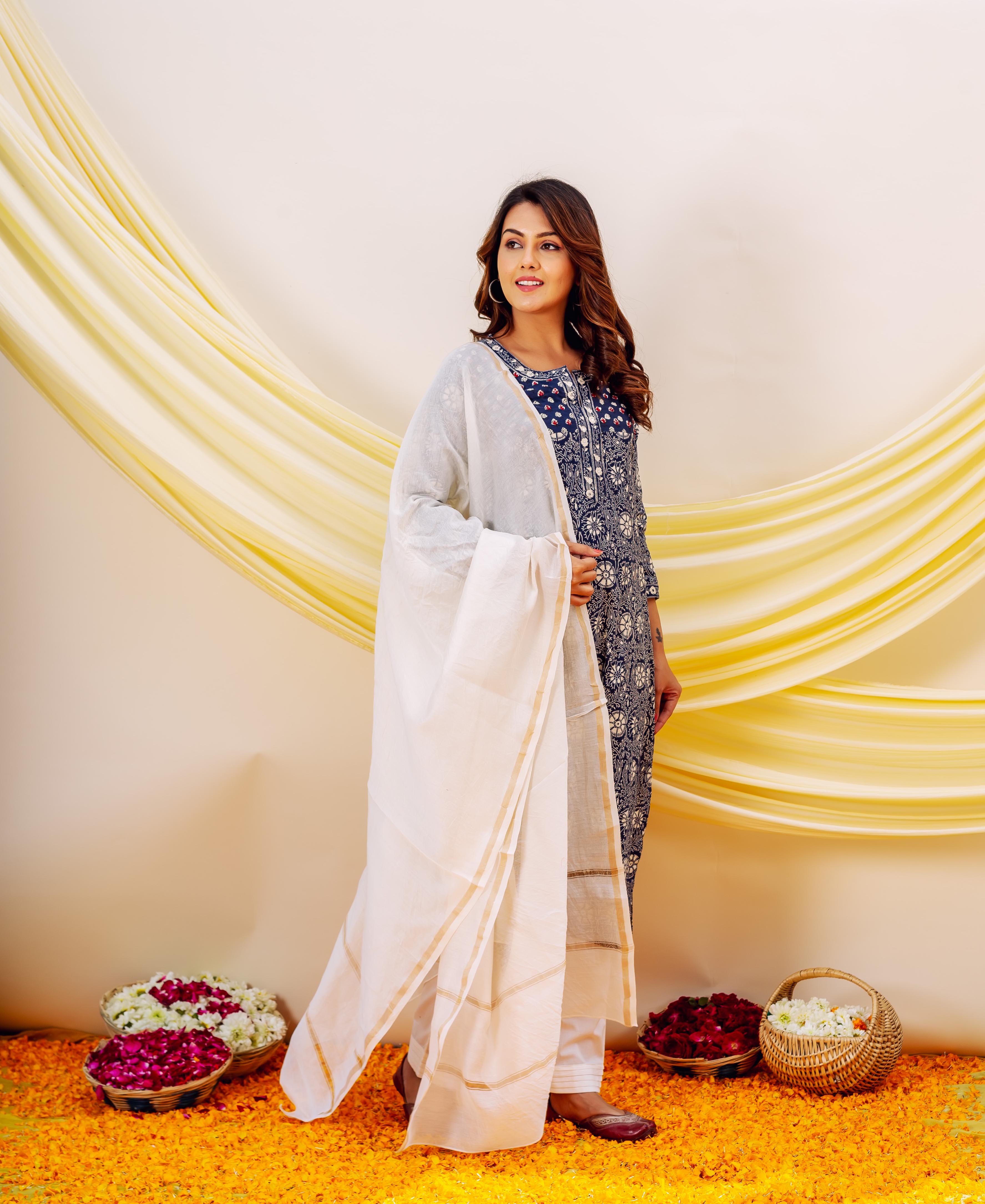 Model in indigo hand-block-printed kurta set with white dupatta and golden border.