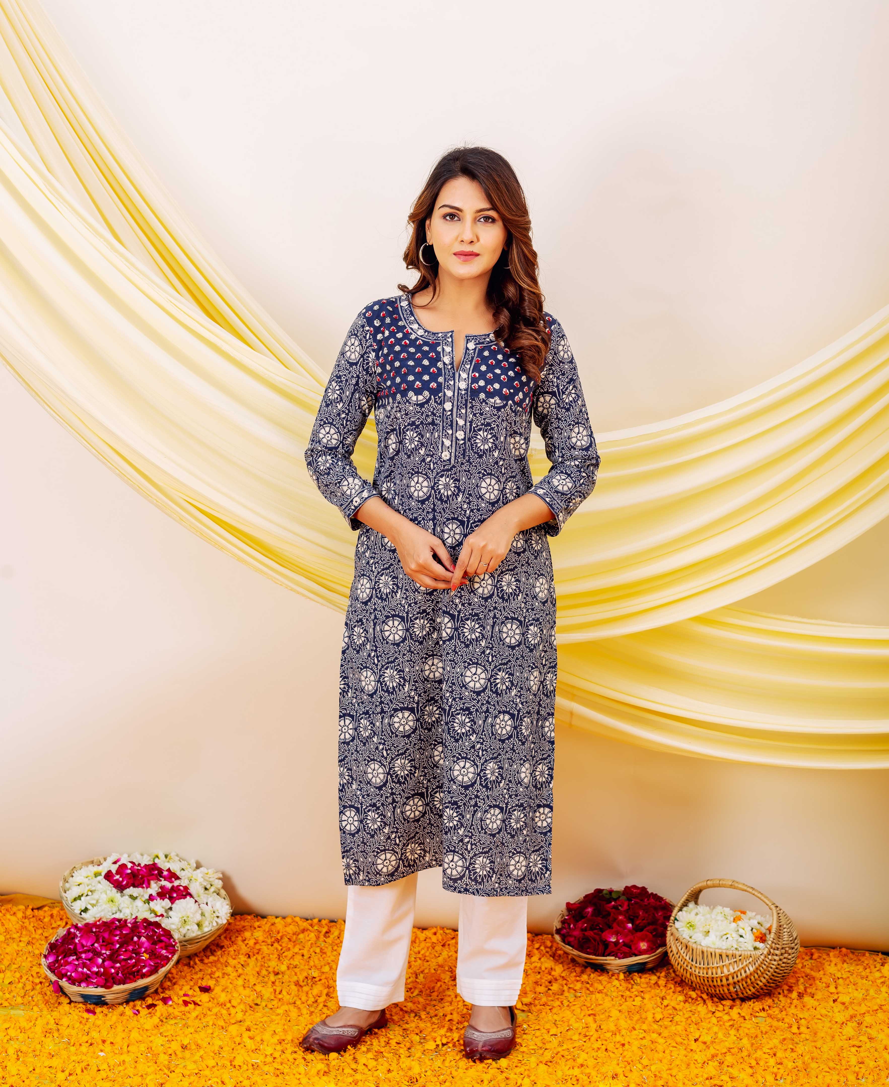 A woman models a blue and white floral print kurta with embroidery on the chest.