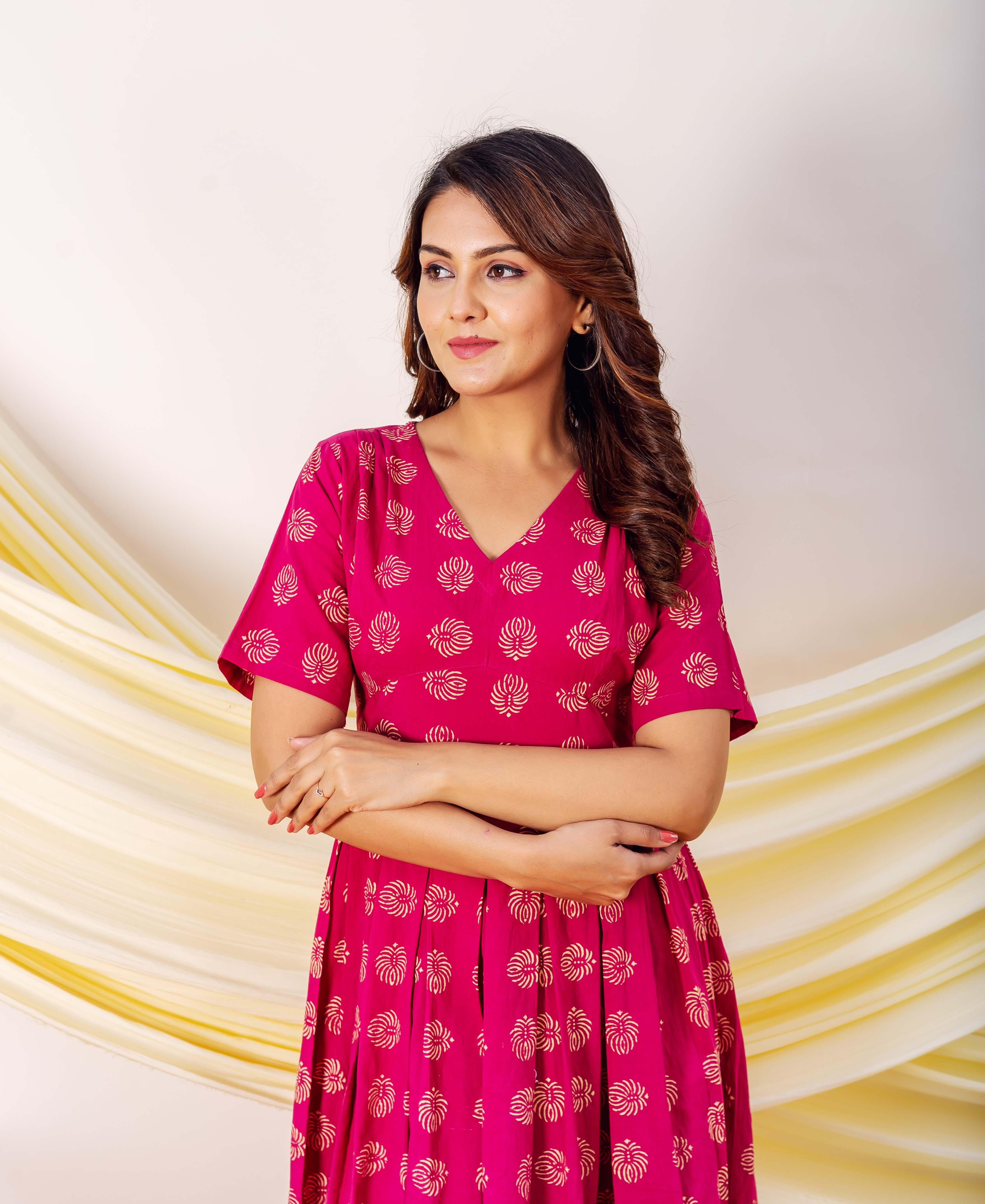 Model in fuchsia hand-block printed ethnic dress with intricate gold motifs.