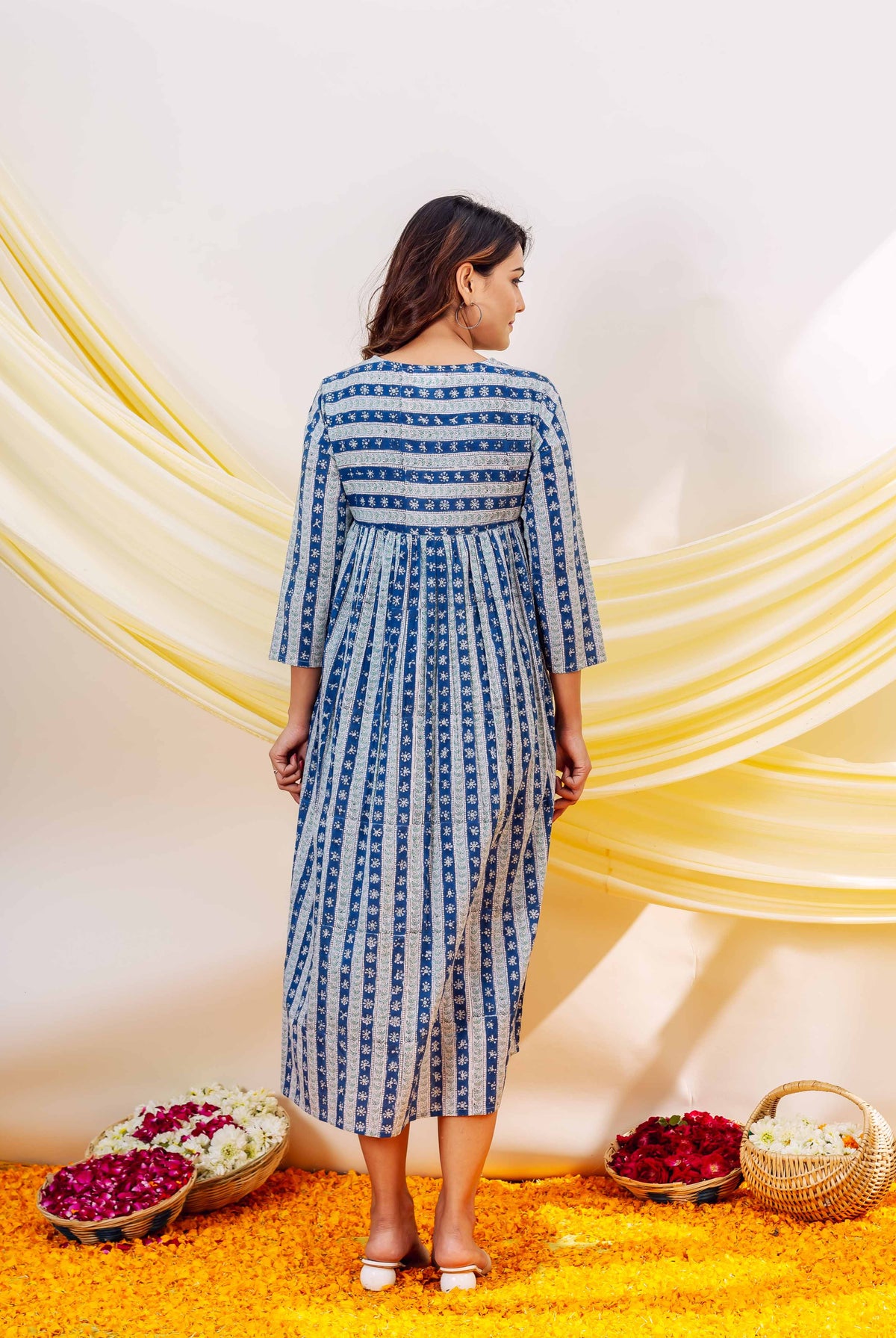 Back of woman in indigo blue and white hand-block printed striped dress.