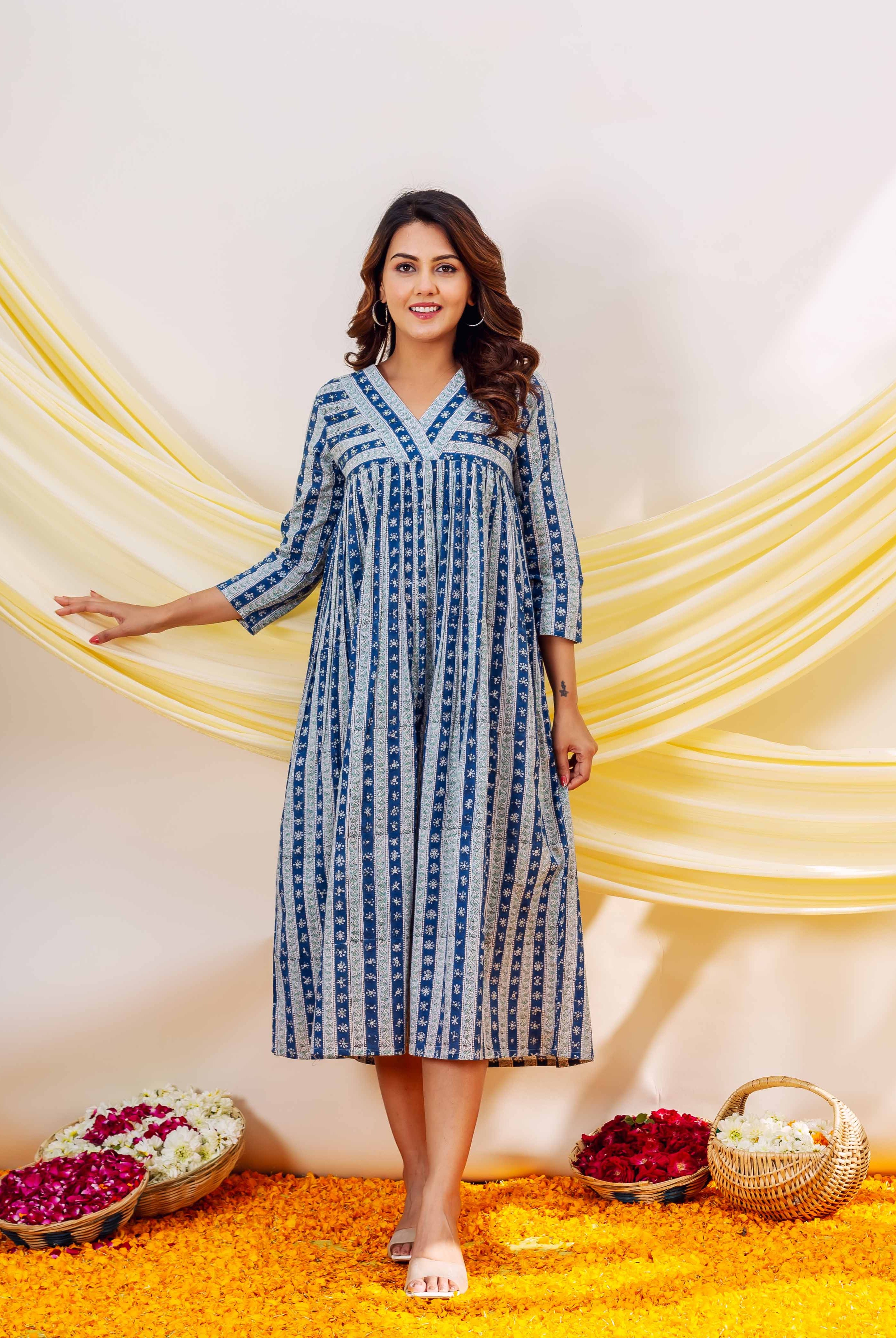 Smiling woman, front view, wearing an indigo blue and white striped block-printed midi dress.