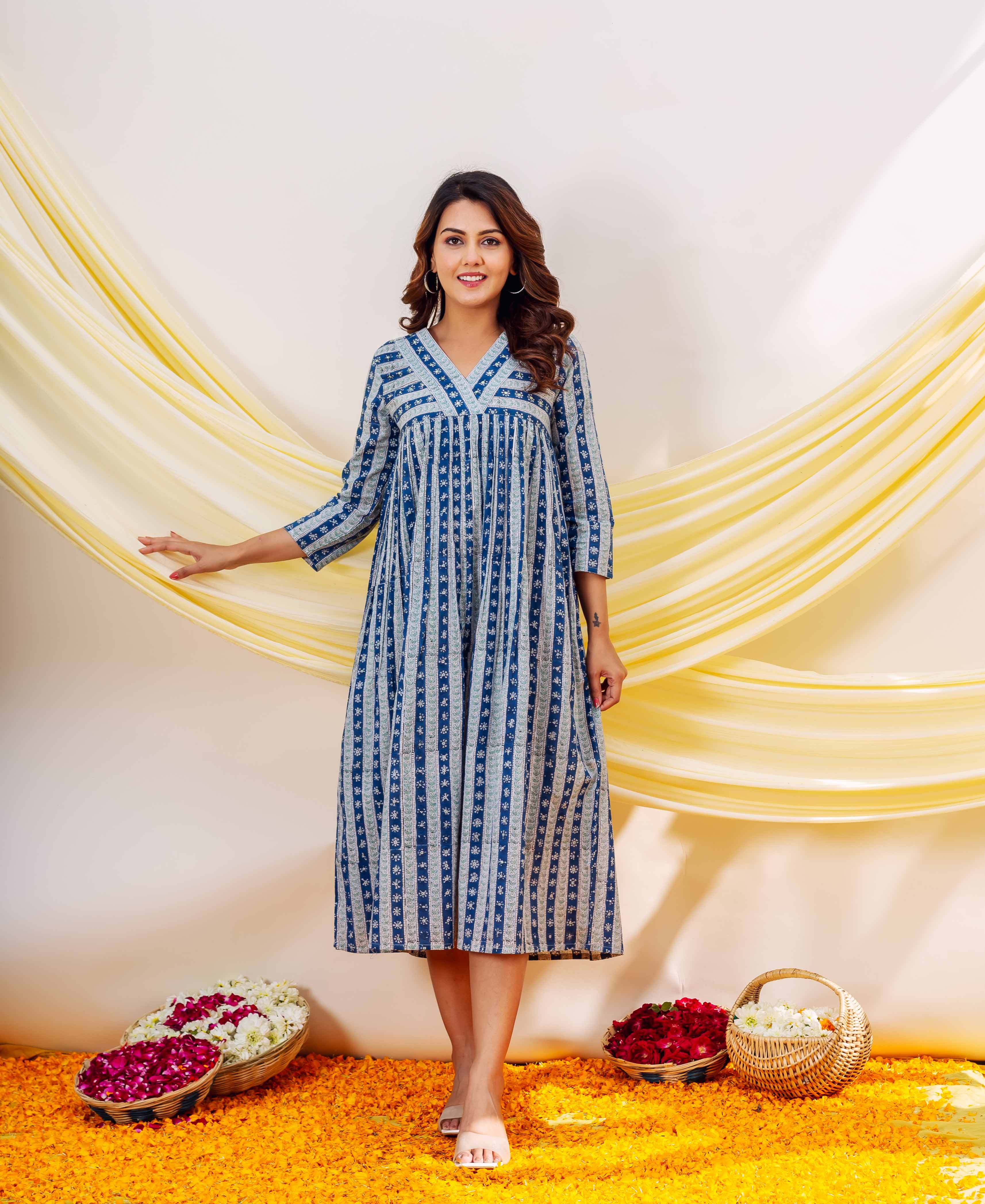 Smiling woman, front view, wearing an indigo blue and white striped block-printed midi dress.