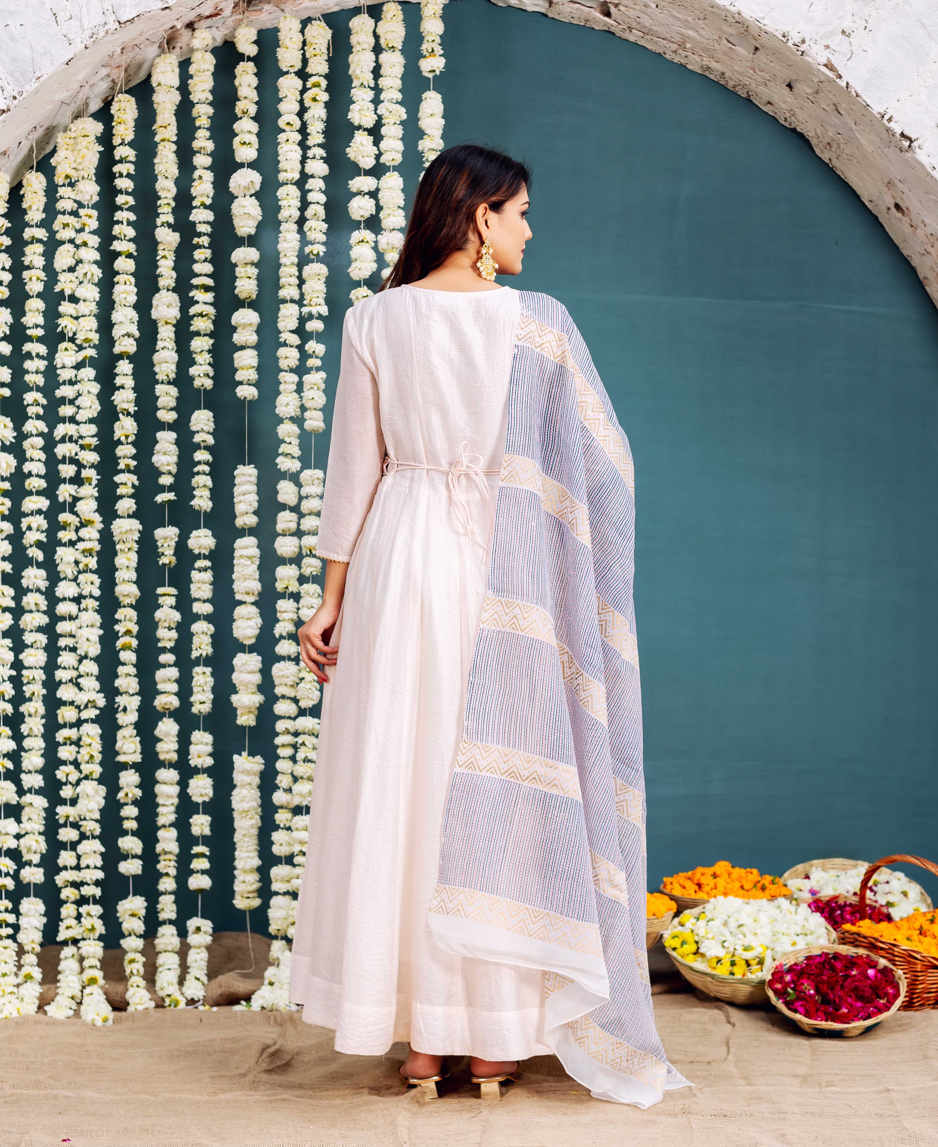 Model from back wearing pale pink Anarkali dress, tie-belt, and blue block-printed dupatta.