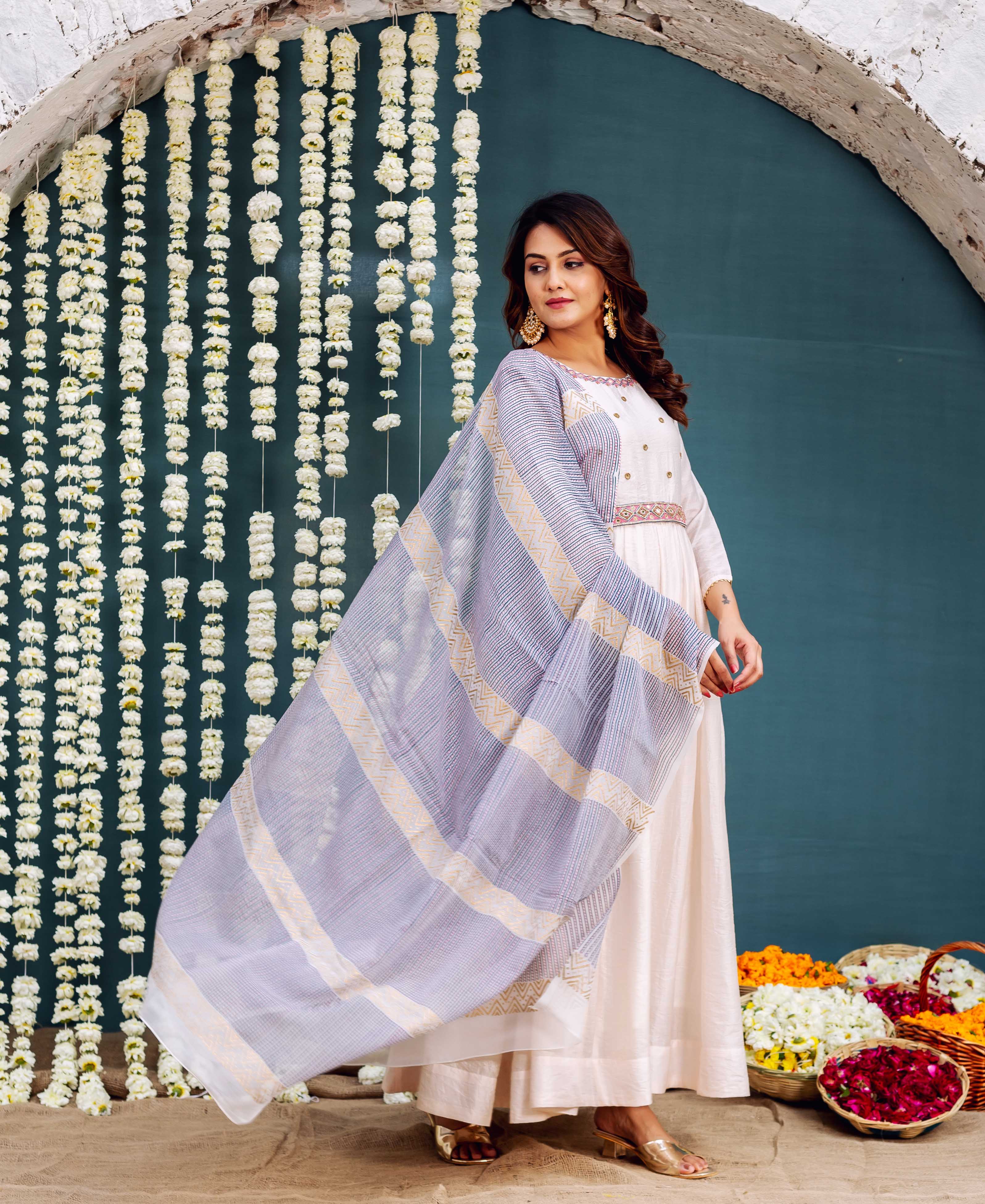 Model wearing cream Anarkali dress with embroidered belt and striped blue-gold patterned dupatta.