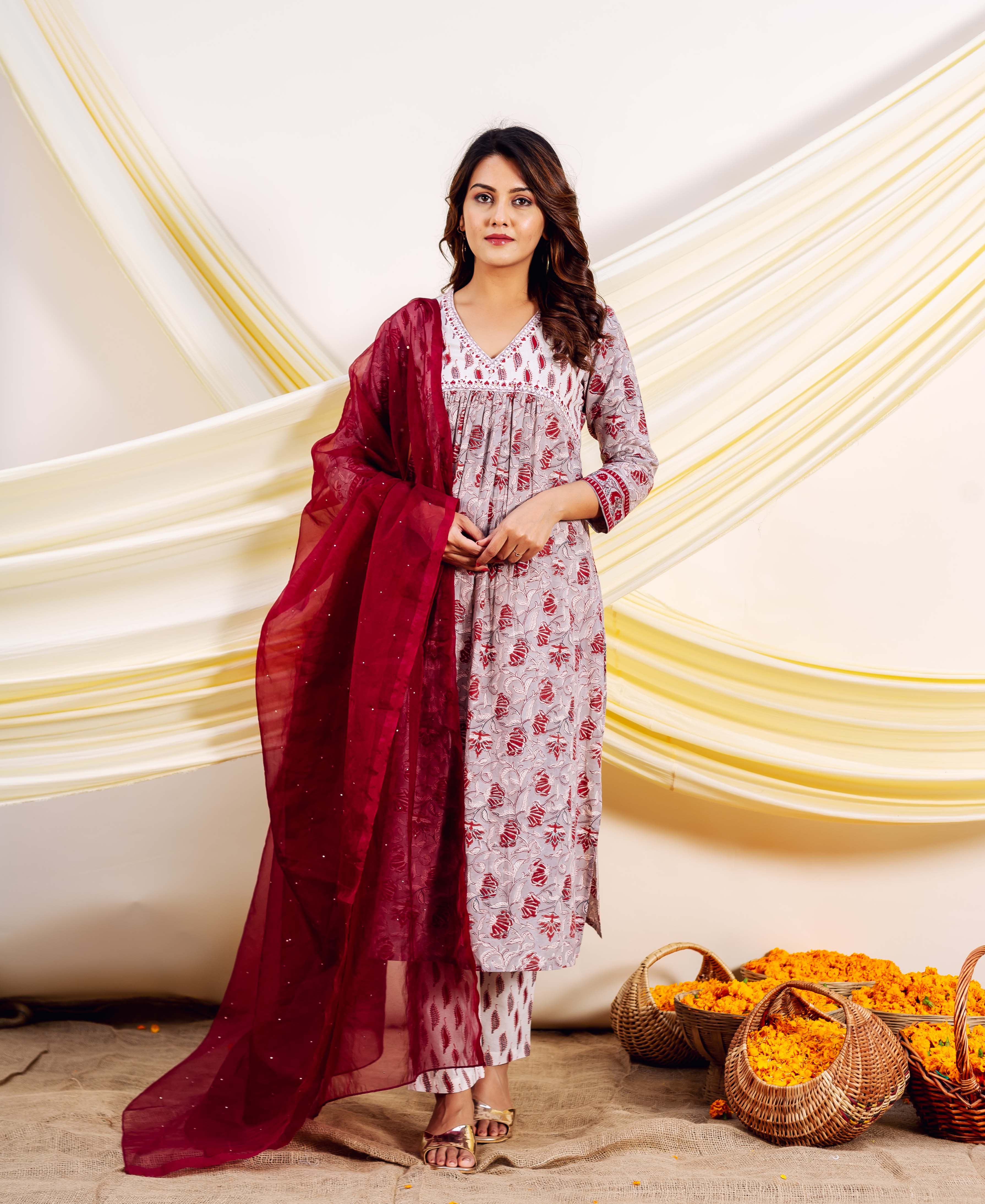 Model in a full grey and red hand-block-printed Naira Kurta set with maroon dupatta.