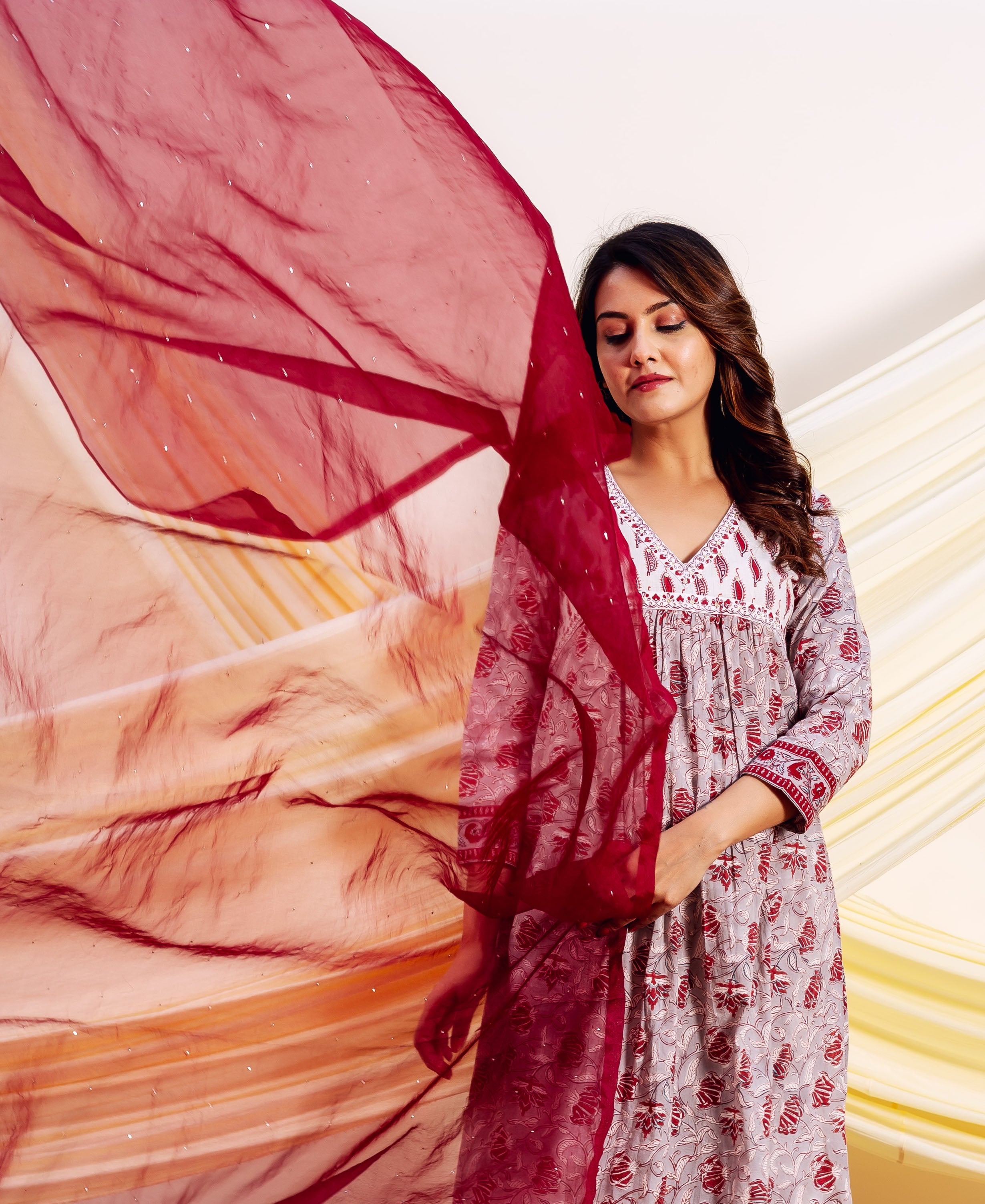 Model in grey and red hand-block printed kurta with embroidered yoke and flowing red dupatta.