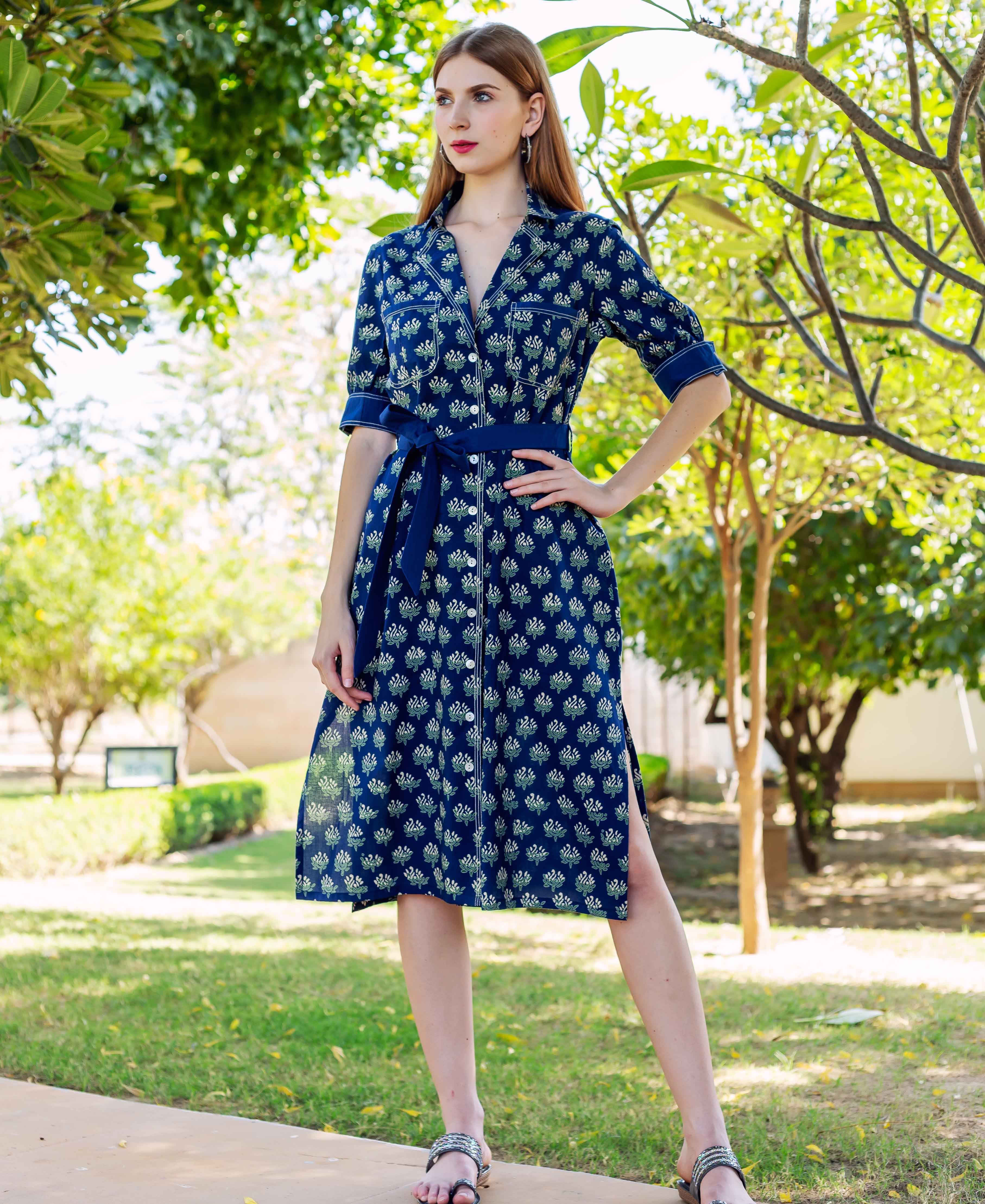 Model wearing indigo hand block printed shirt dress with green and white floral motifs and belt.