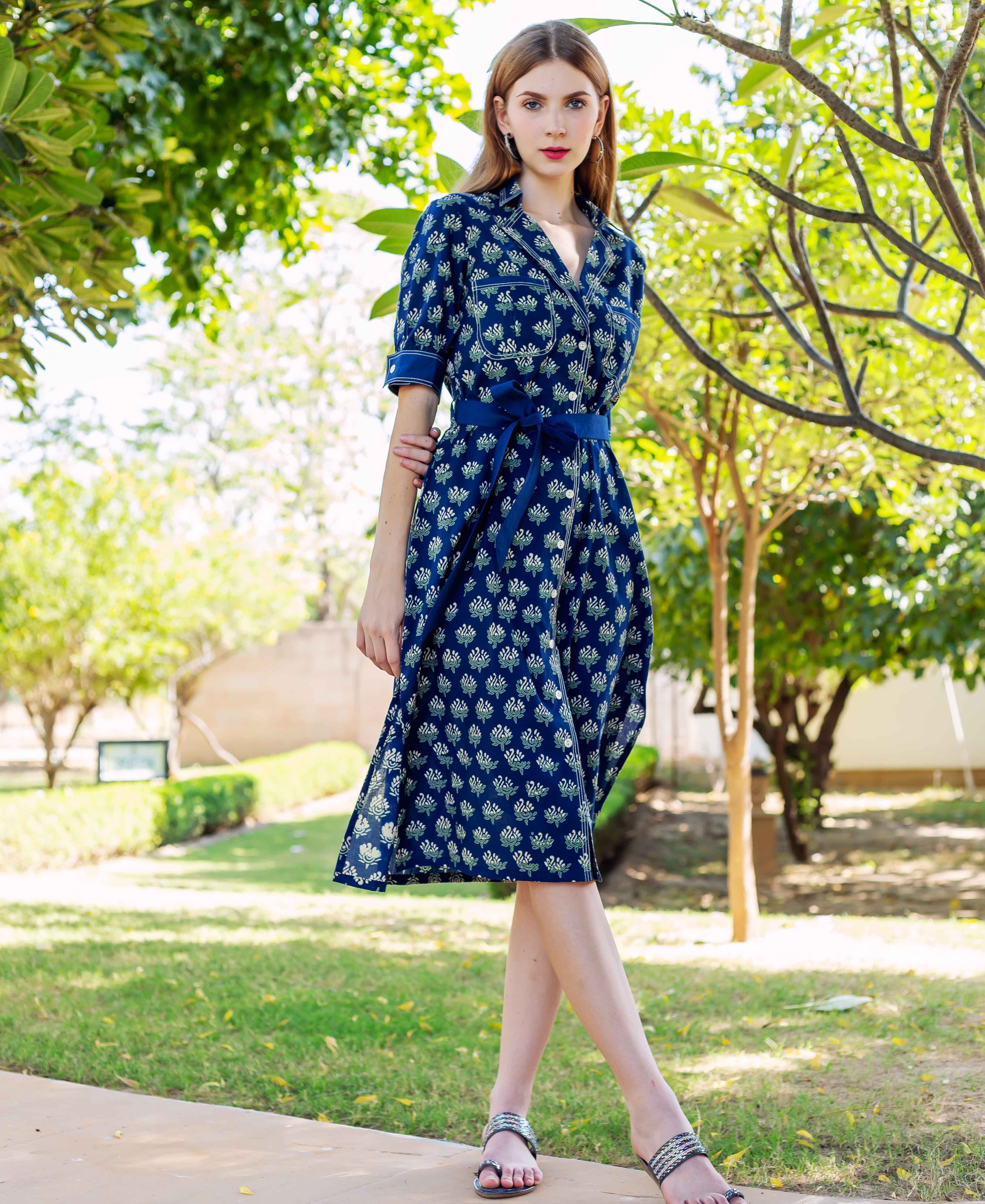 Front view of model wearing an indigo hand block printed midi dress with light floral motifs.