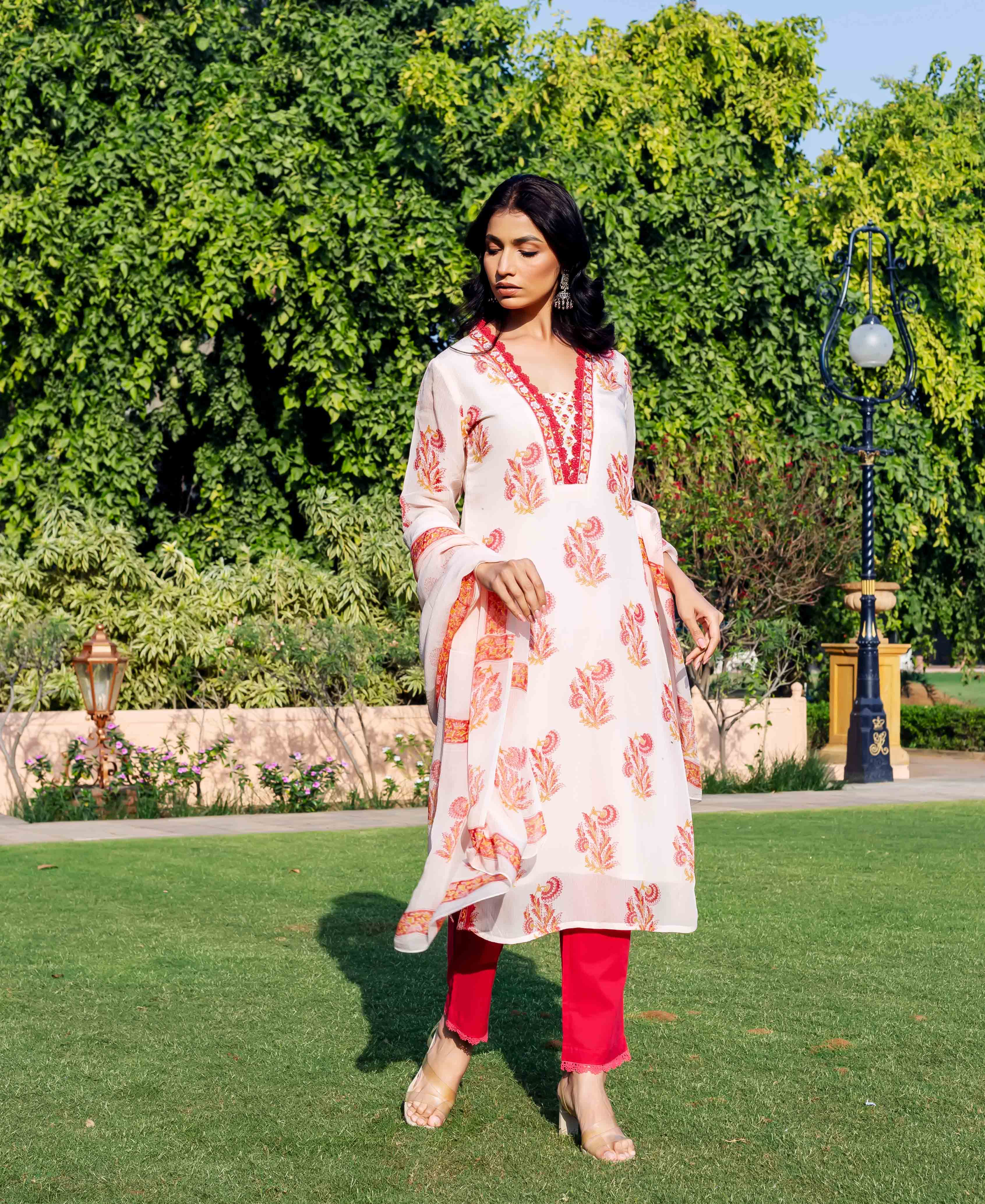 Model wears off-white organza kurta with red floral hand-block print and bright red pants.
