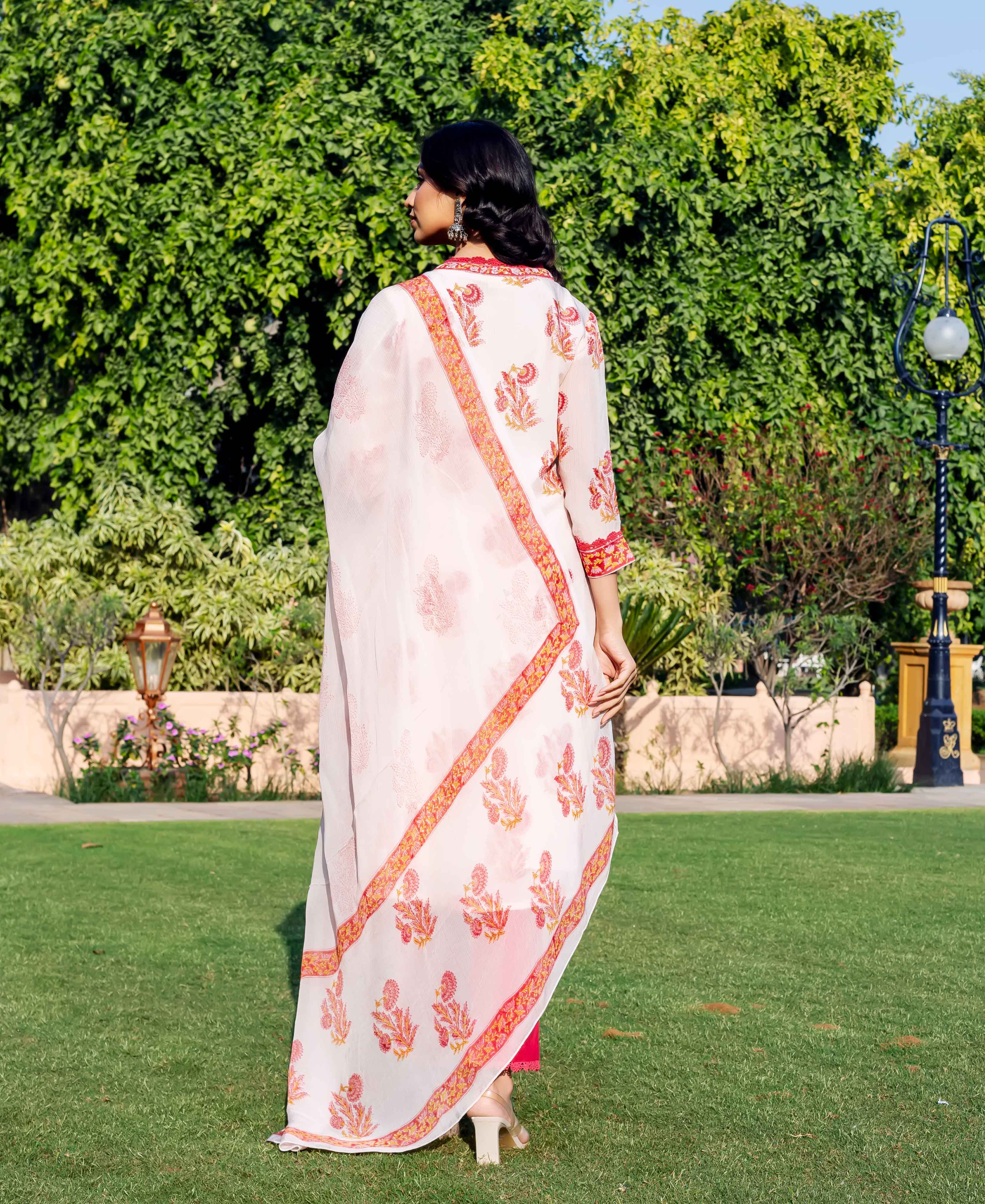 Woman from back in off-white kurta and dupatta with red hand-block printed floral patterns.