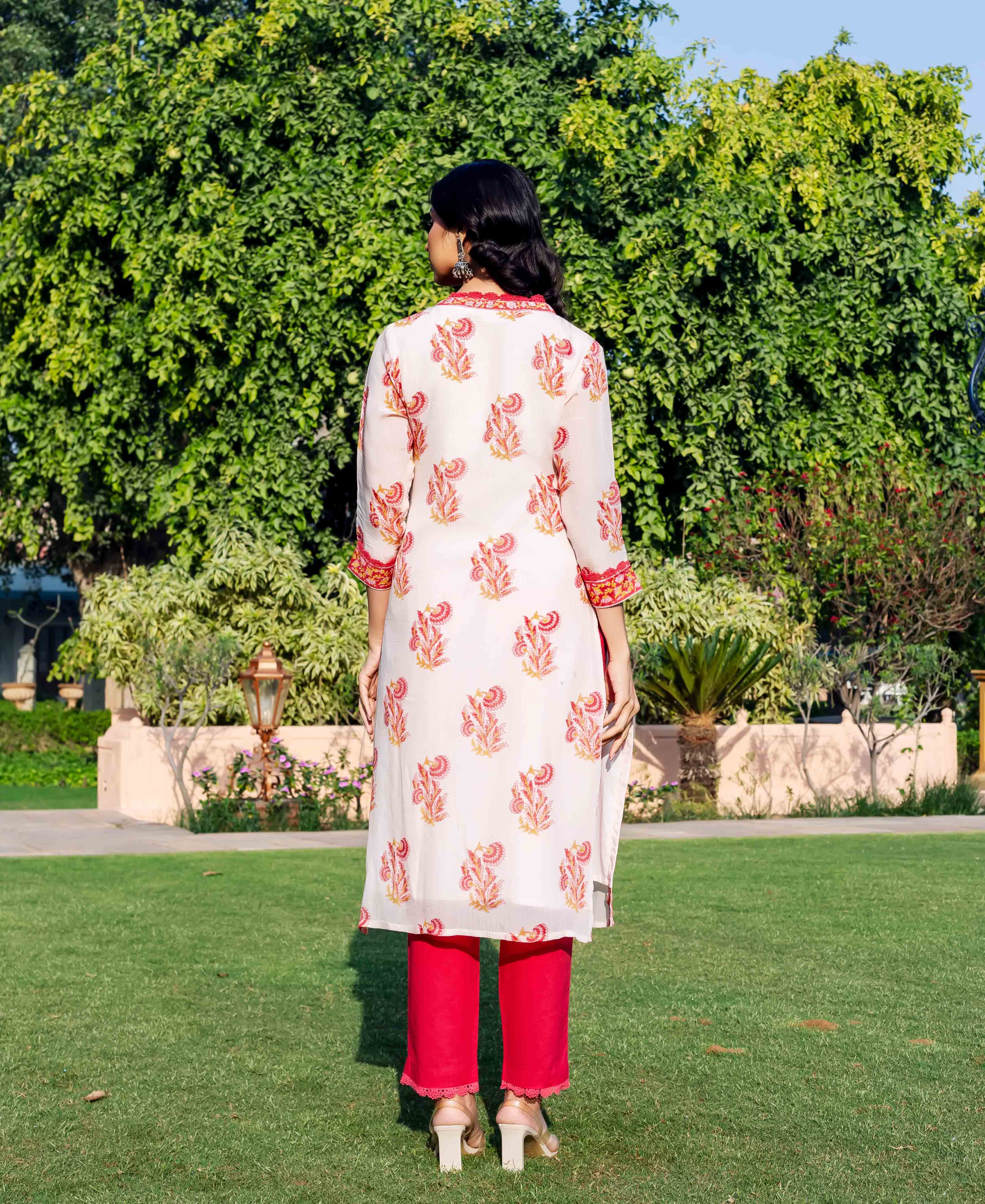 Model from behind wearing off-white hand-block-printed organza kurta with red floral patterns and red pants.