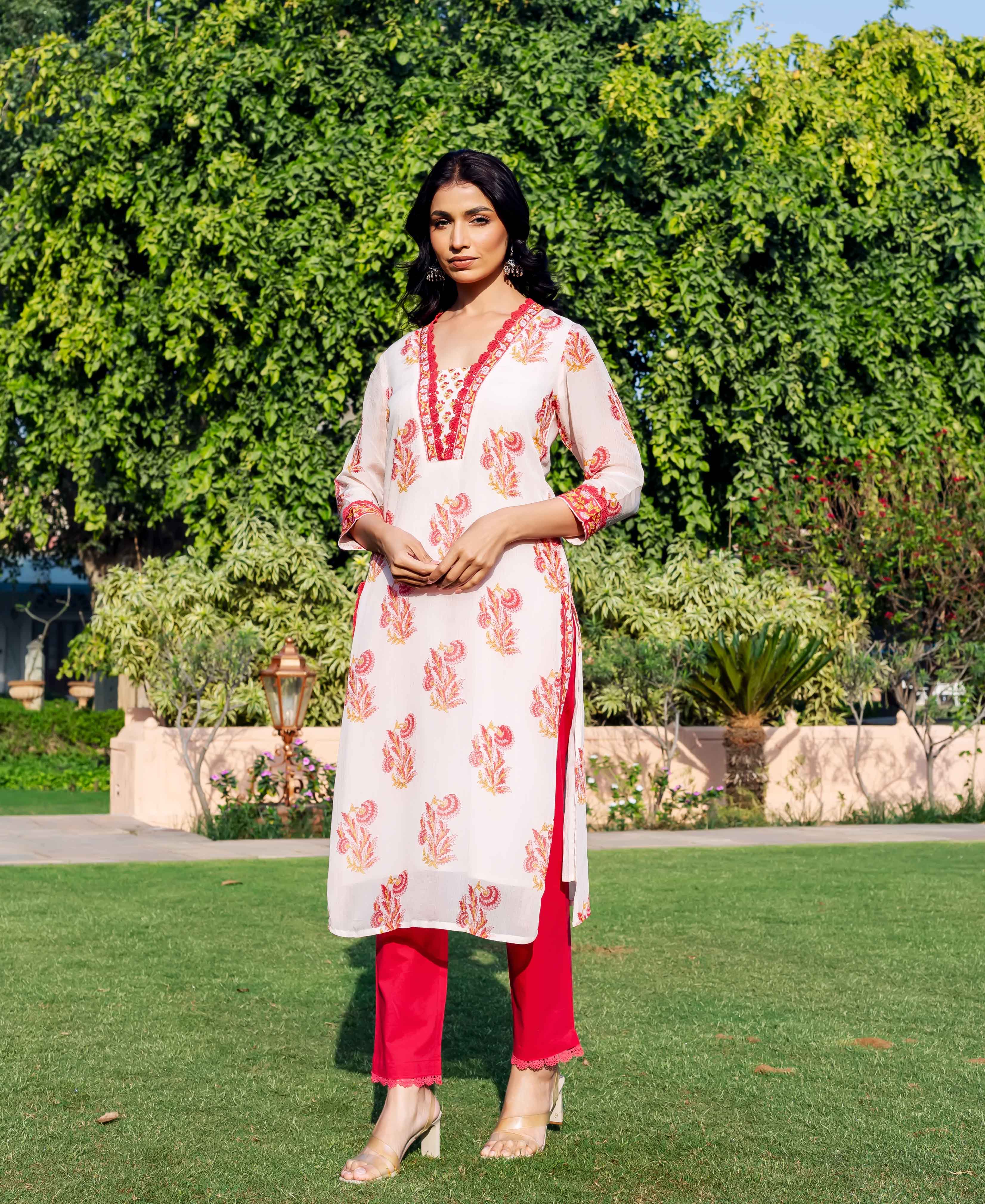 Off-white organza kurta with red and orange floral print, red trim, on a model outdoors.