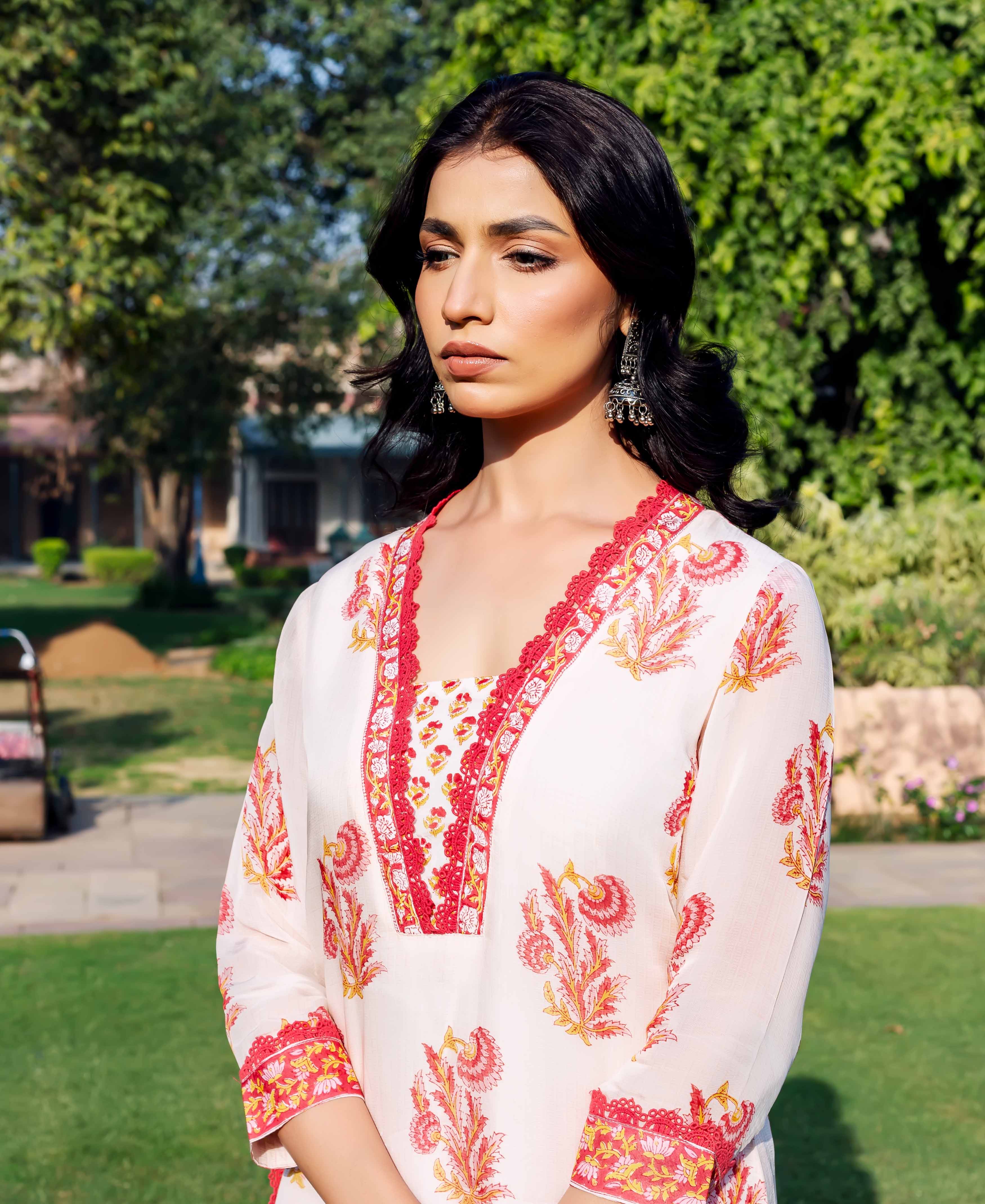 Model in off-white kurta with red and yellow hand-block printed ethnic patterns.