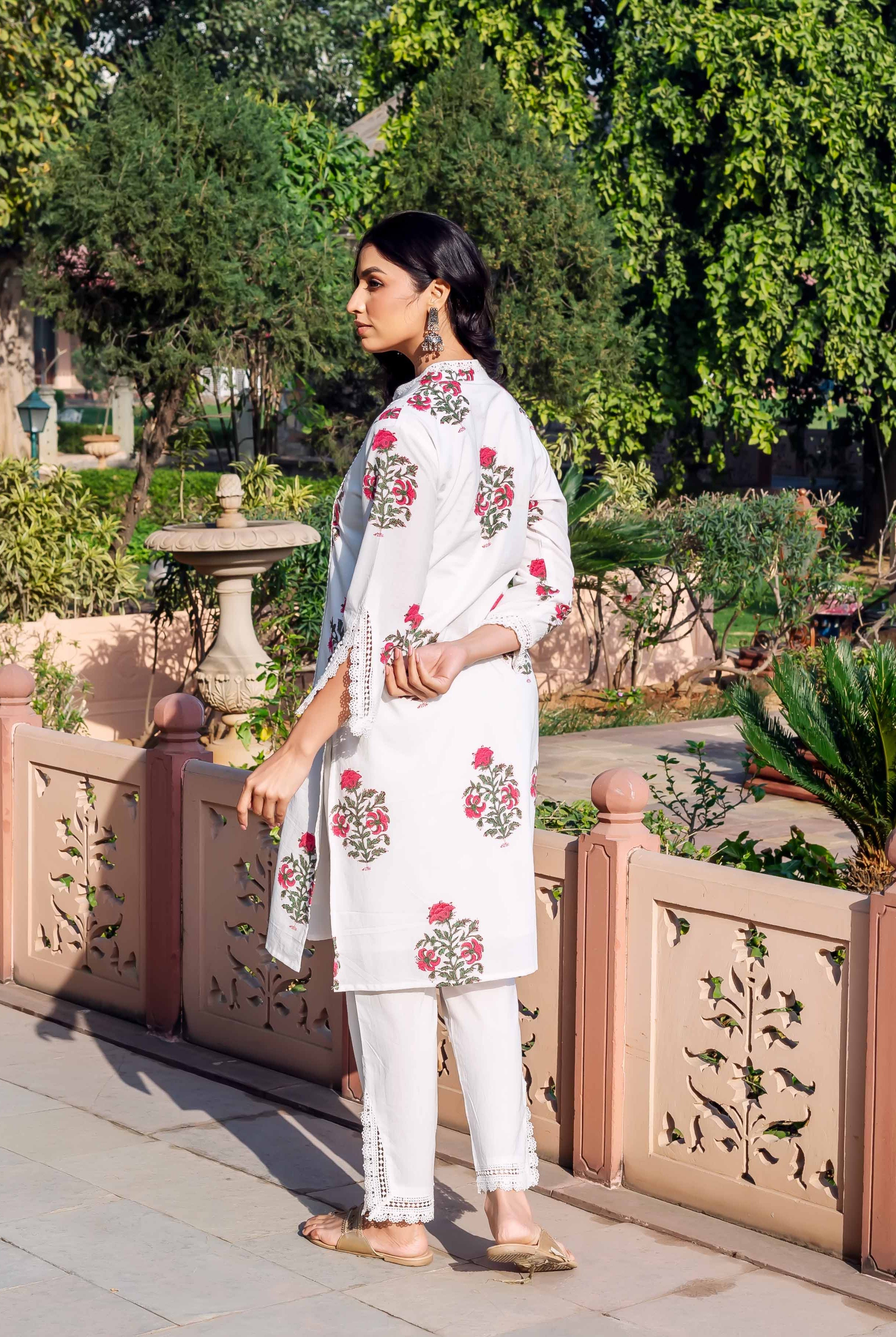 Side view of model in white cotton hand-block-printed kurta and pants with red florals.