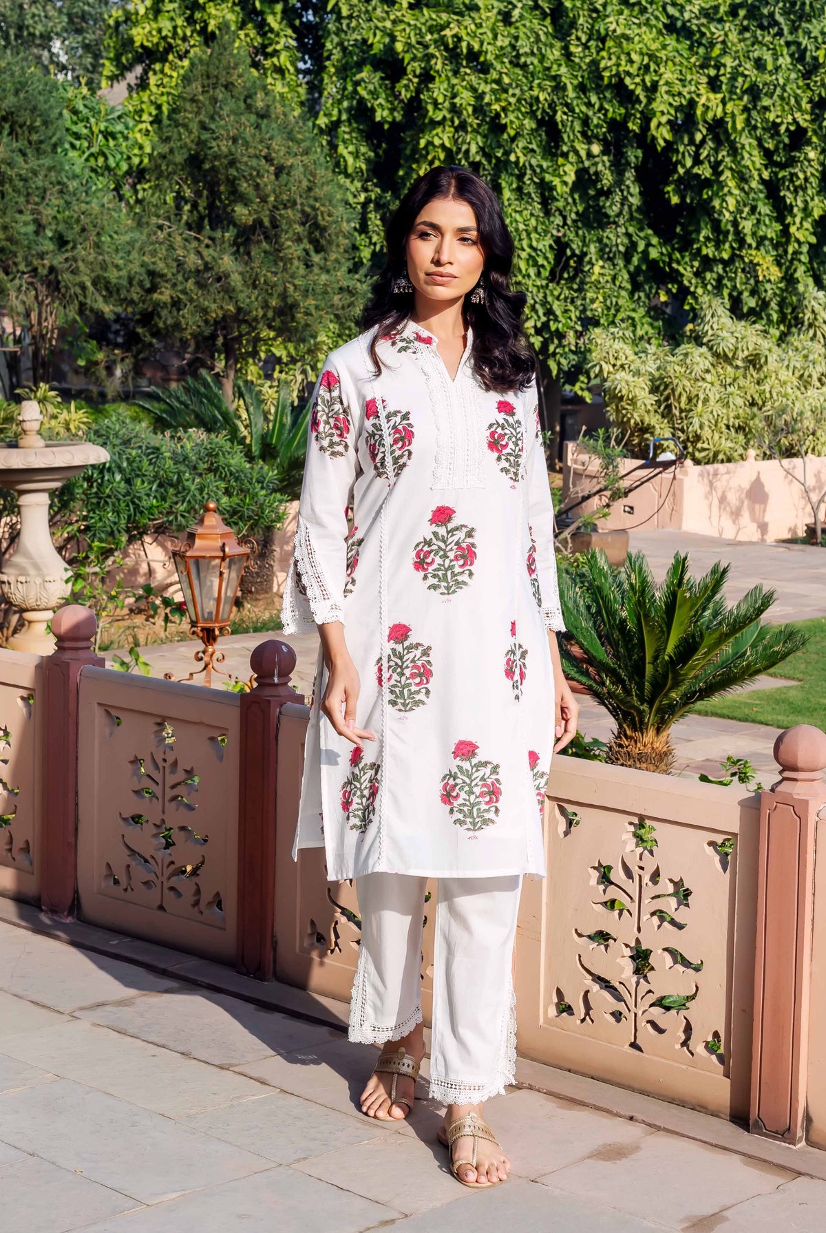 Front view of model wearing white cotton kurta with red floral hand-block print and matching pants.
