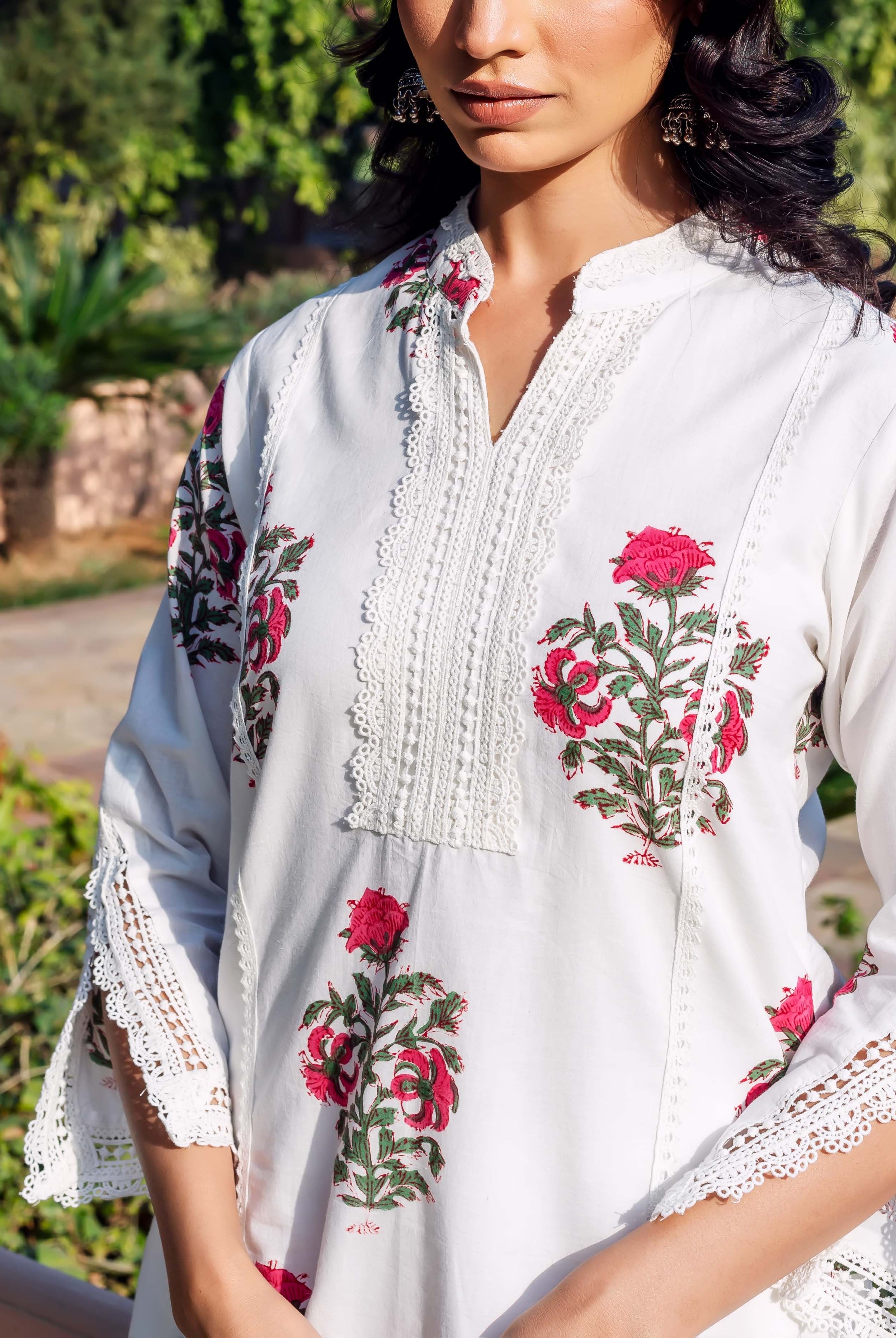 Model wears white cotton kurta, pink floral block print, prominent lace on yoke and sleeves.