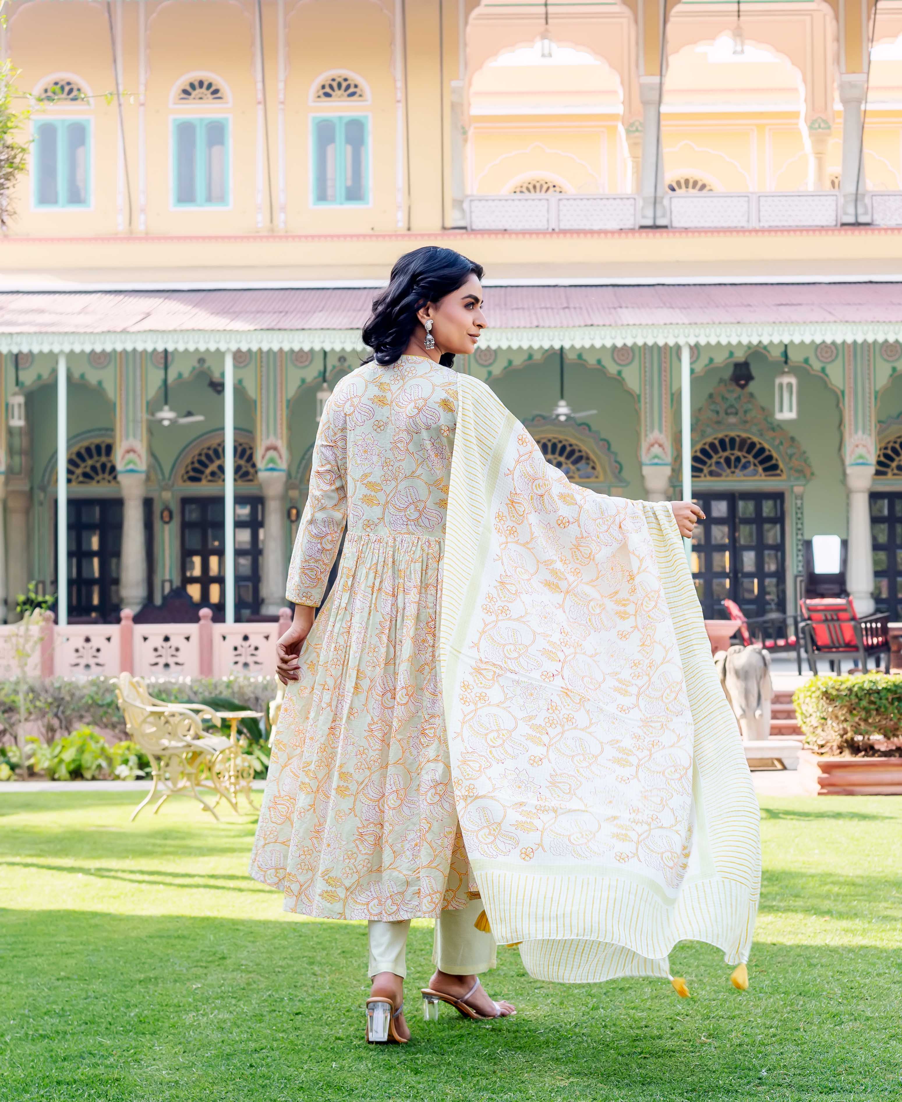 Back view: woman in light green floral block print kurta with yellow striped dupatta.