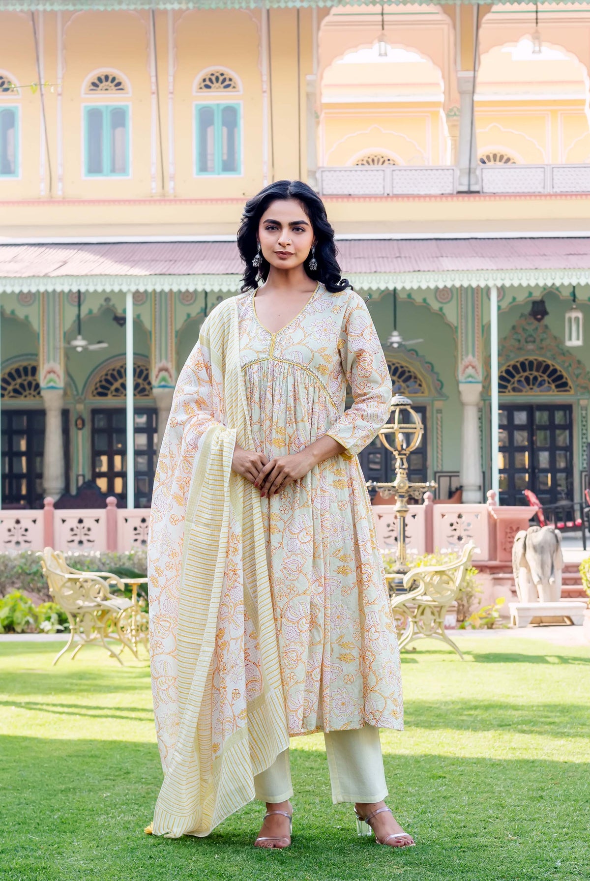 Full shot of a model wearing a light yellow floral hand-block printed kurta set.