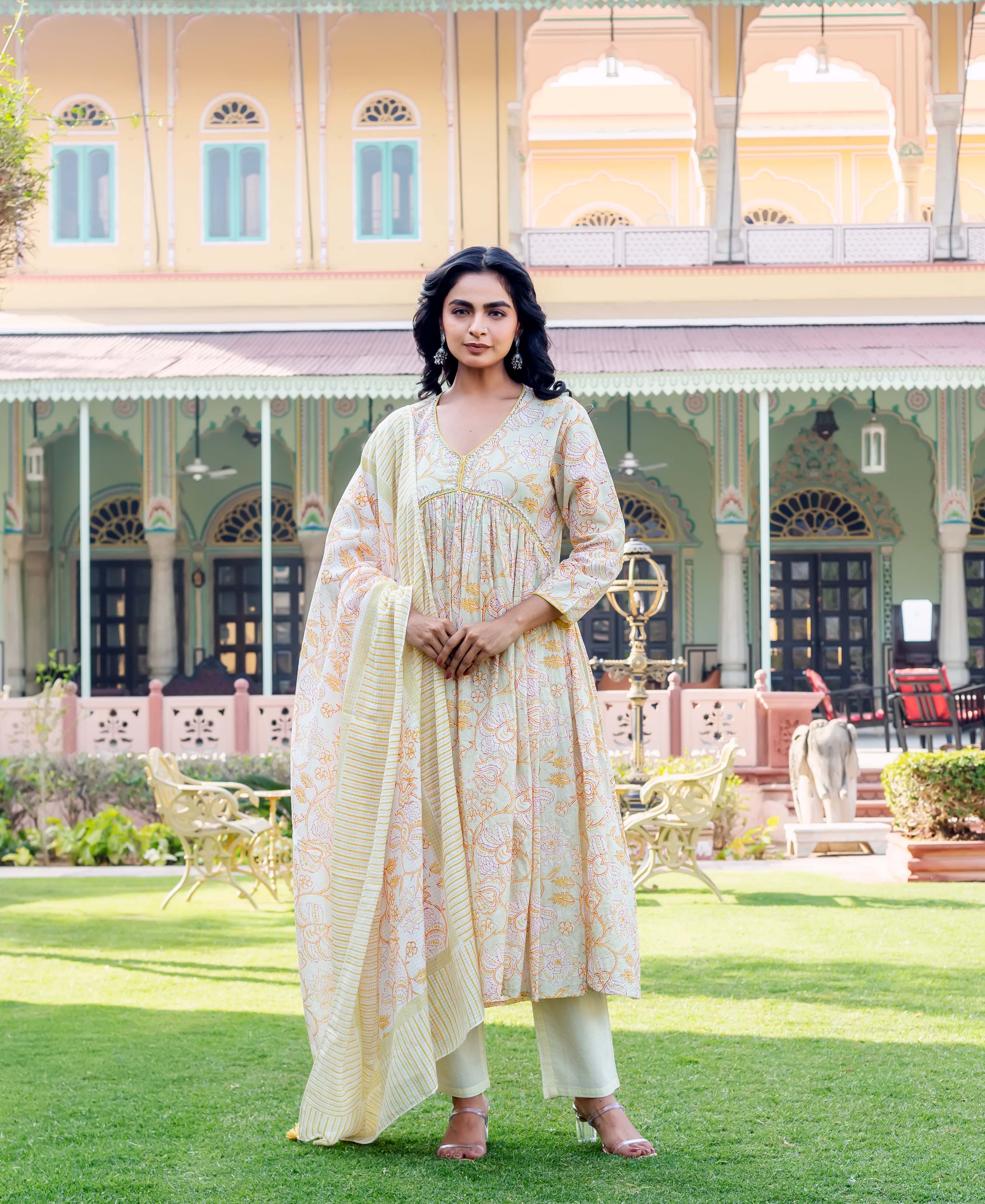 Full shot of a model wearing a light yellow floral hand-block printed kurta set.