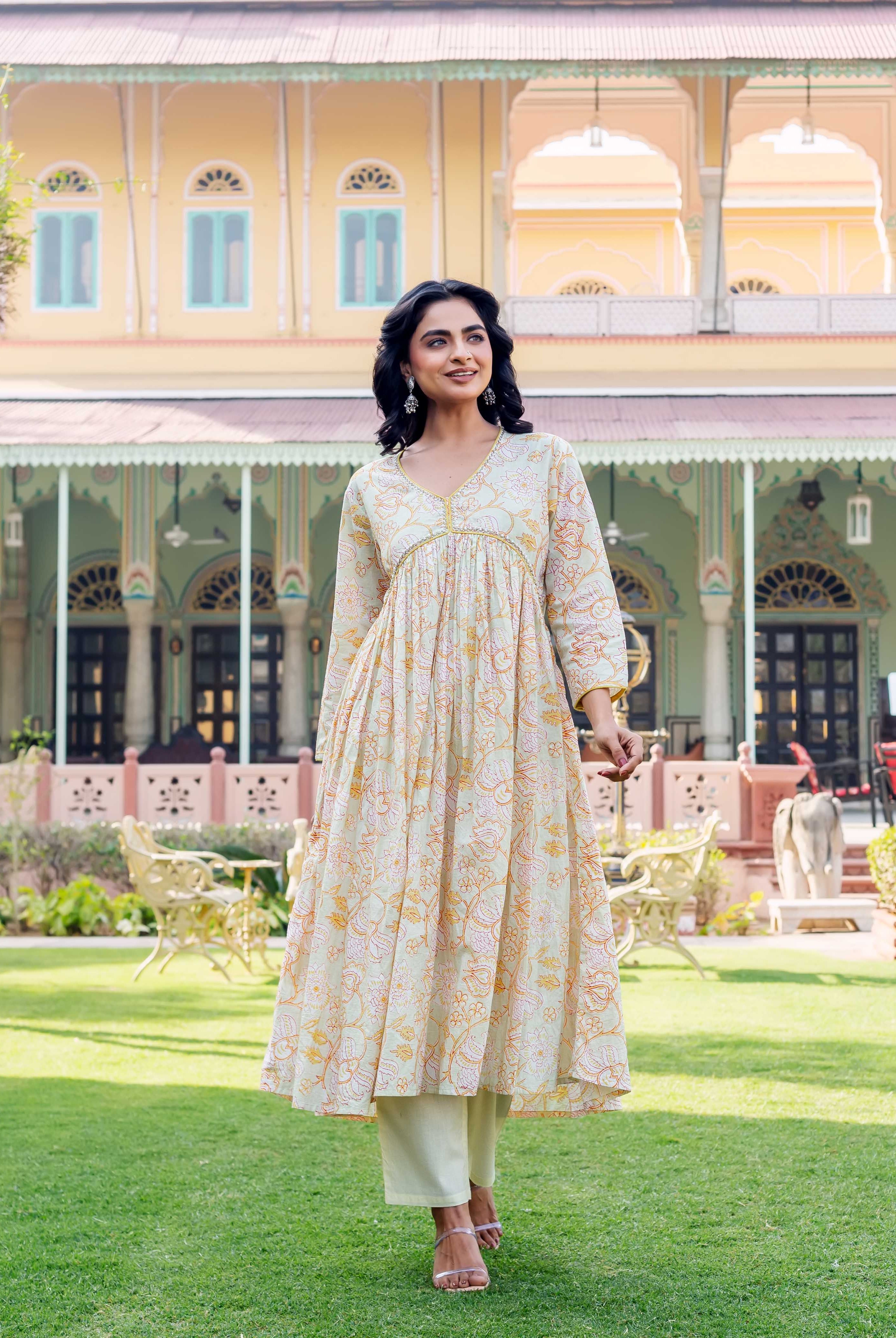 Full shot of model in pastel green hand-block-printed floral kurta with light pants, walking.