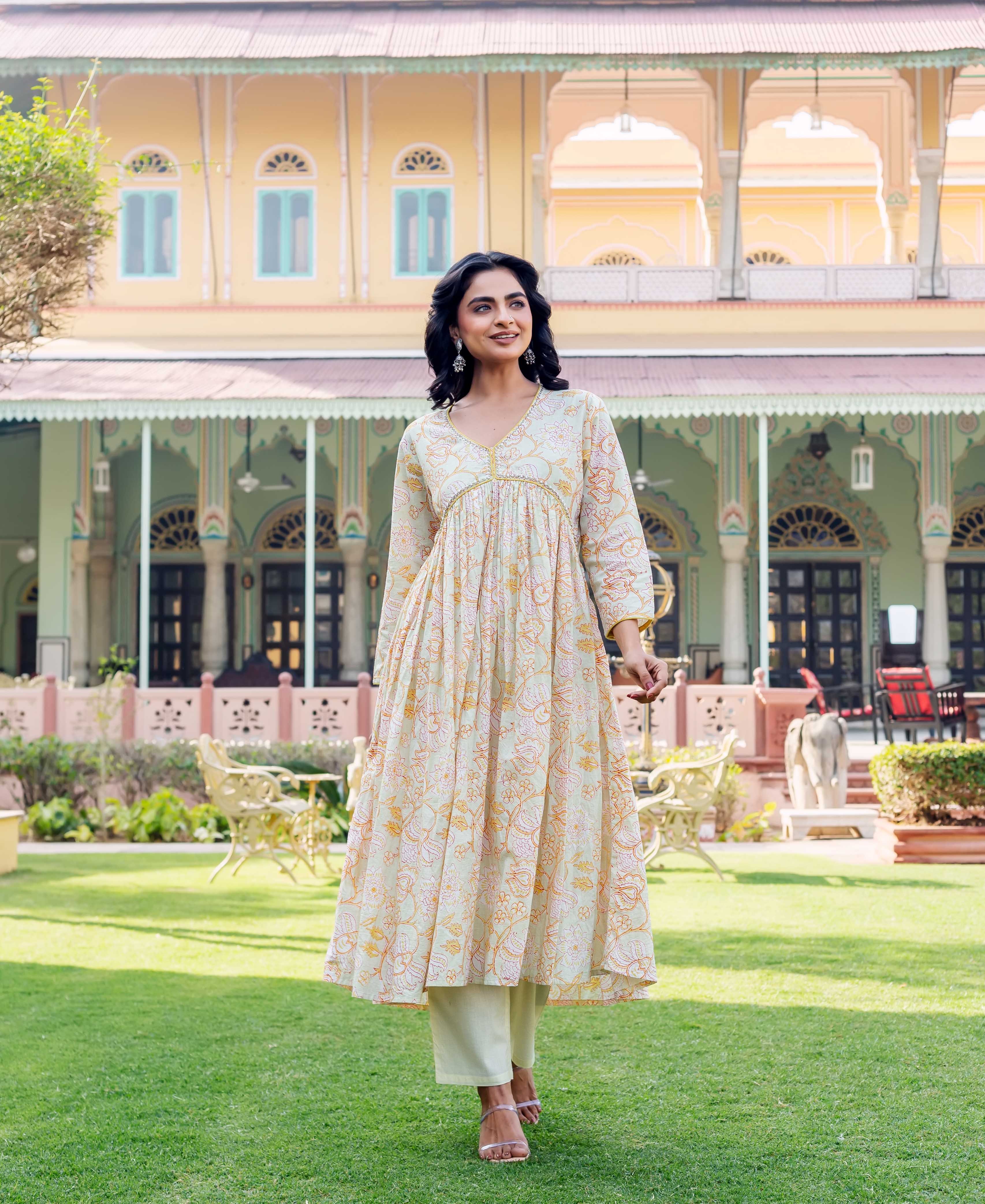 Full shot of model in pastel green hand-block-printed floral kurta with light pants, walking.