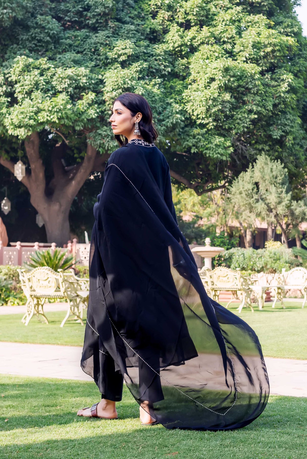 Side view of model in black Nishita Kota Check Kurta with silver embroidery.