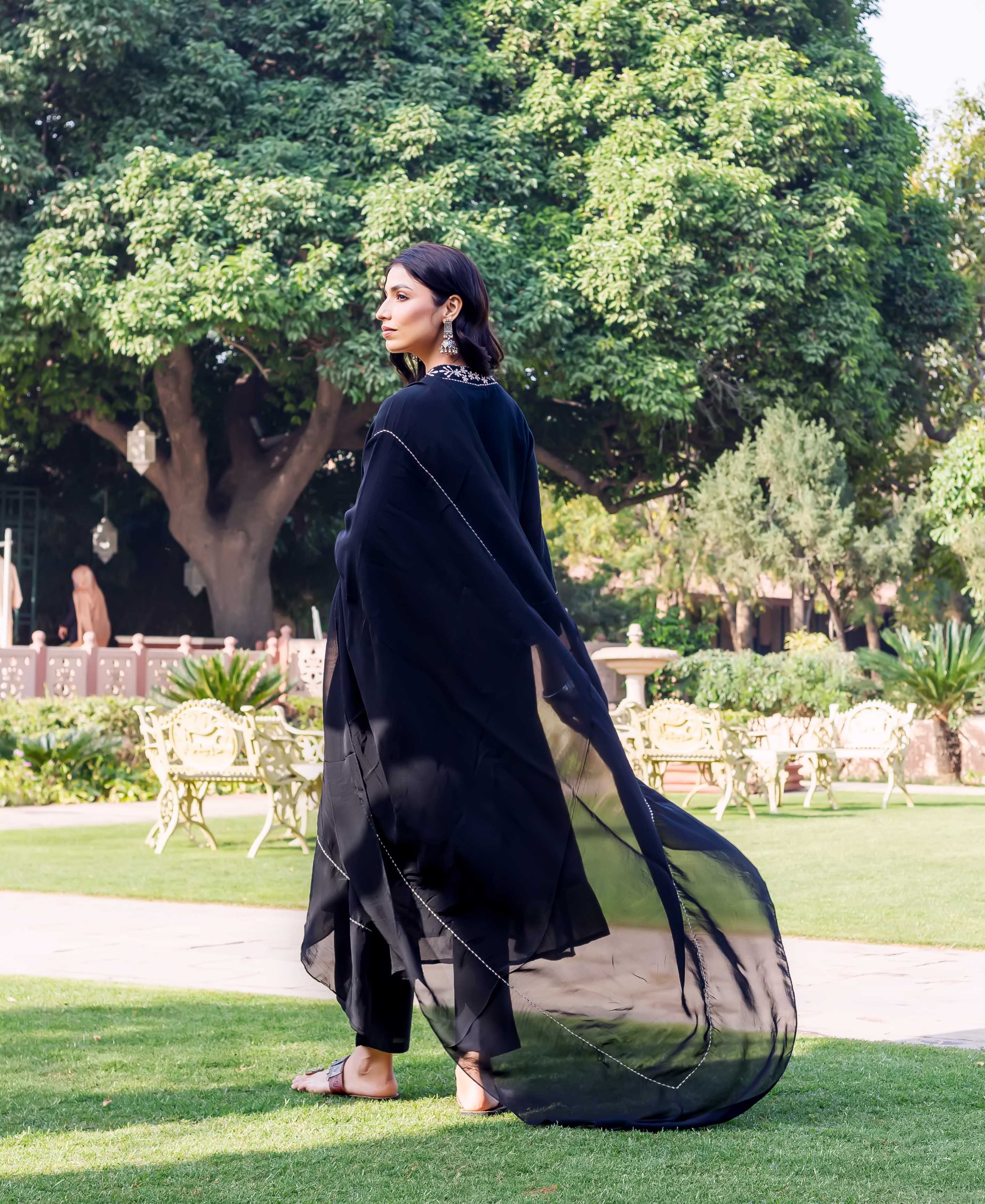 Side view of model in black Nishita Kota Check Kurta with silver embroidery.
