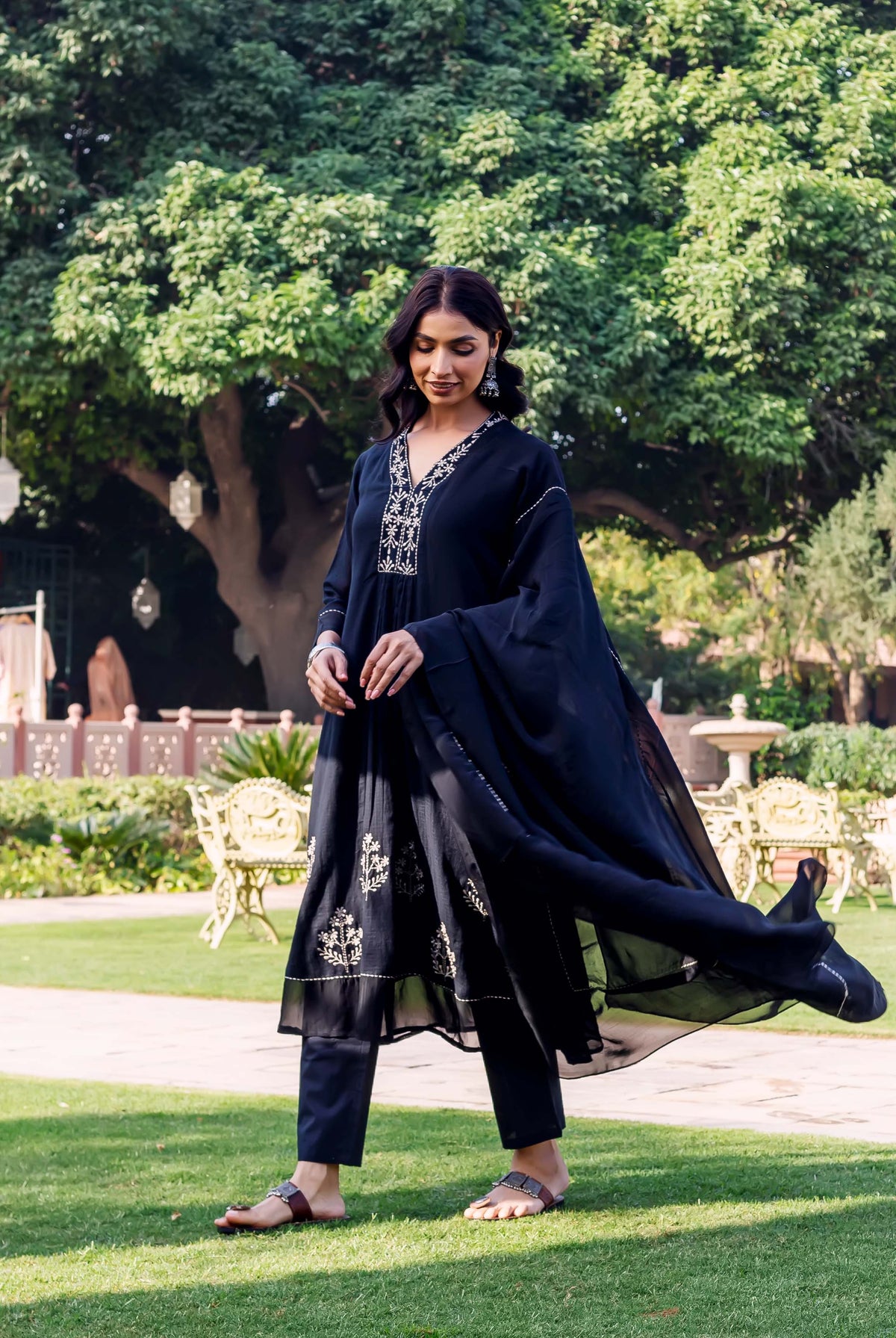 Model in black ethnic kurta set with white embroidered details and flowing dupatta.