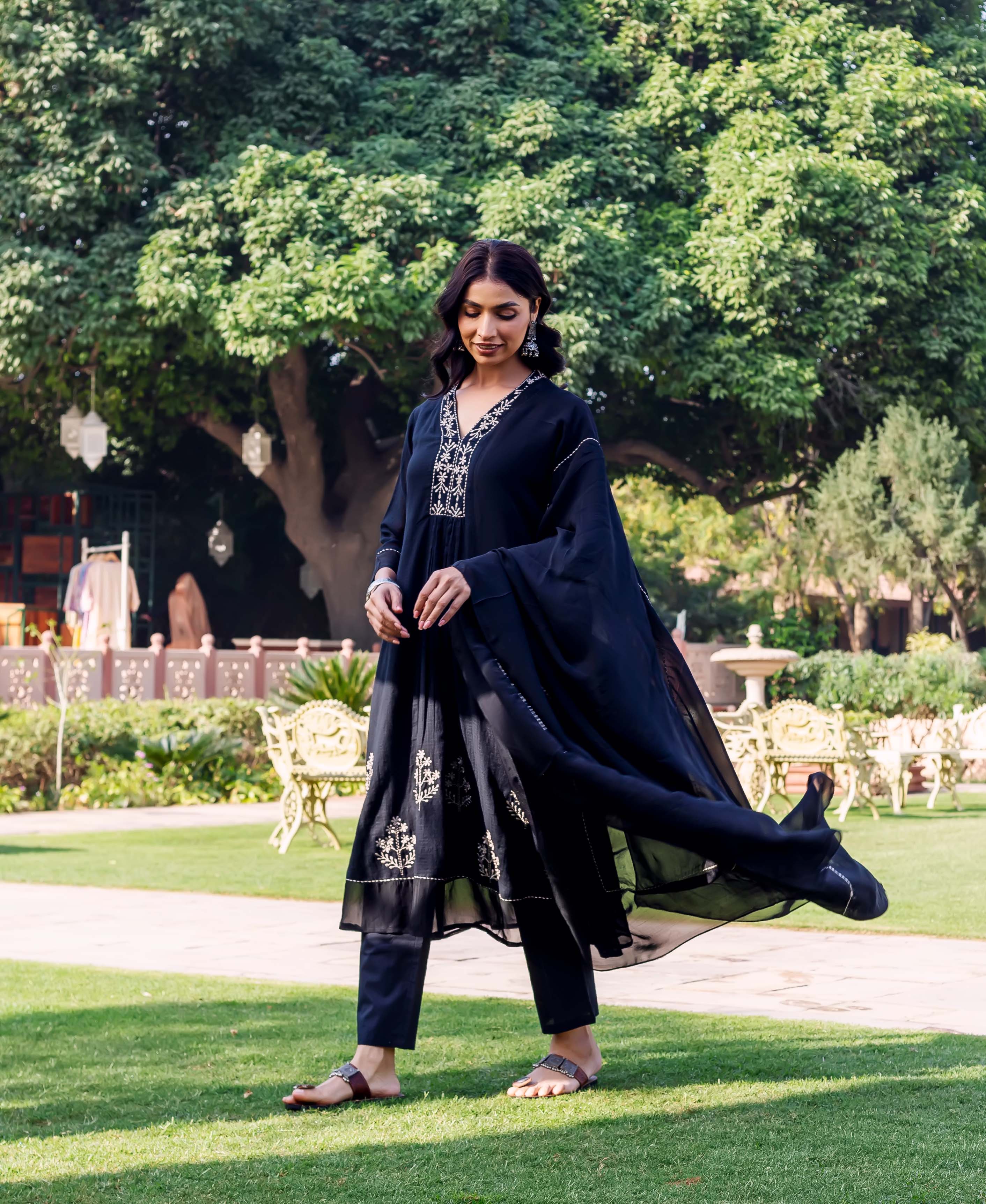Model in black ethnic kurta set with white embroidered details and flowing dupatta.