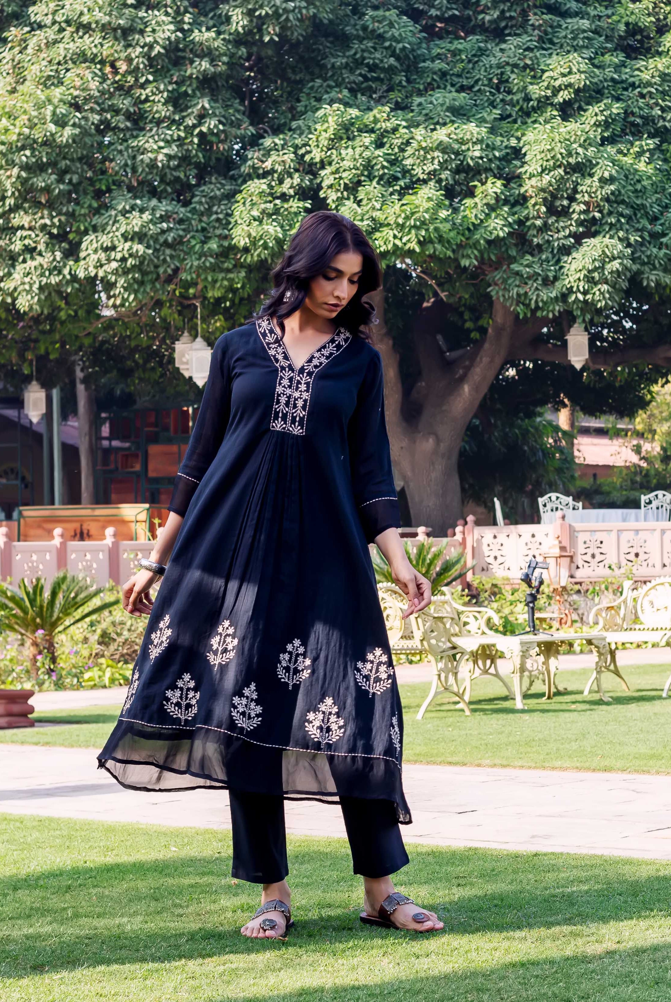 Full-length model in a dark blue ethnic kurta with white V-neck and hem prints.