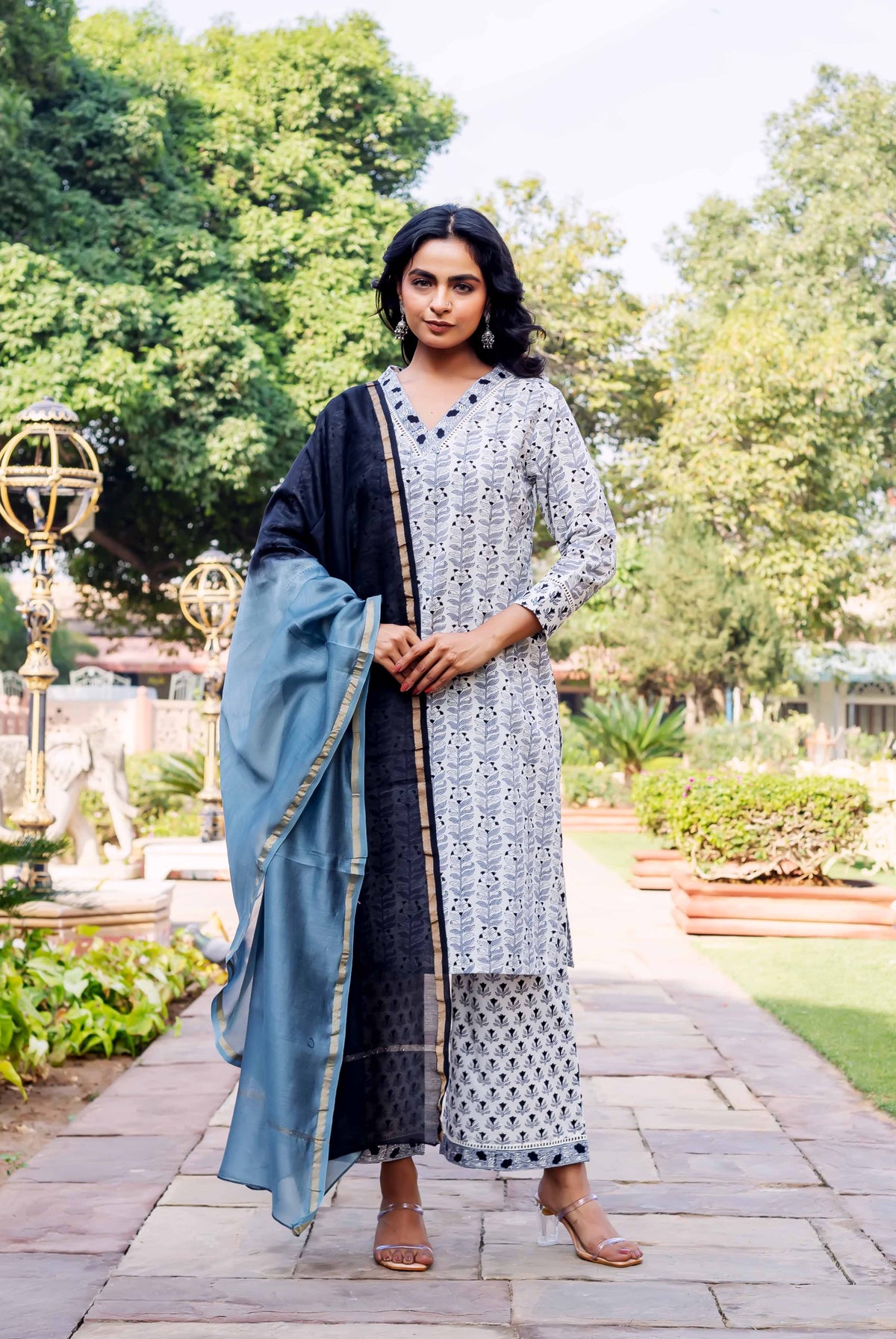 Full front view of model in white black block print kurta, palazzo, and blue dupatta.