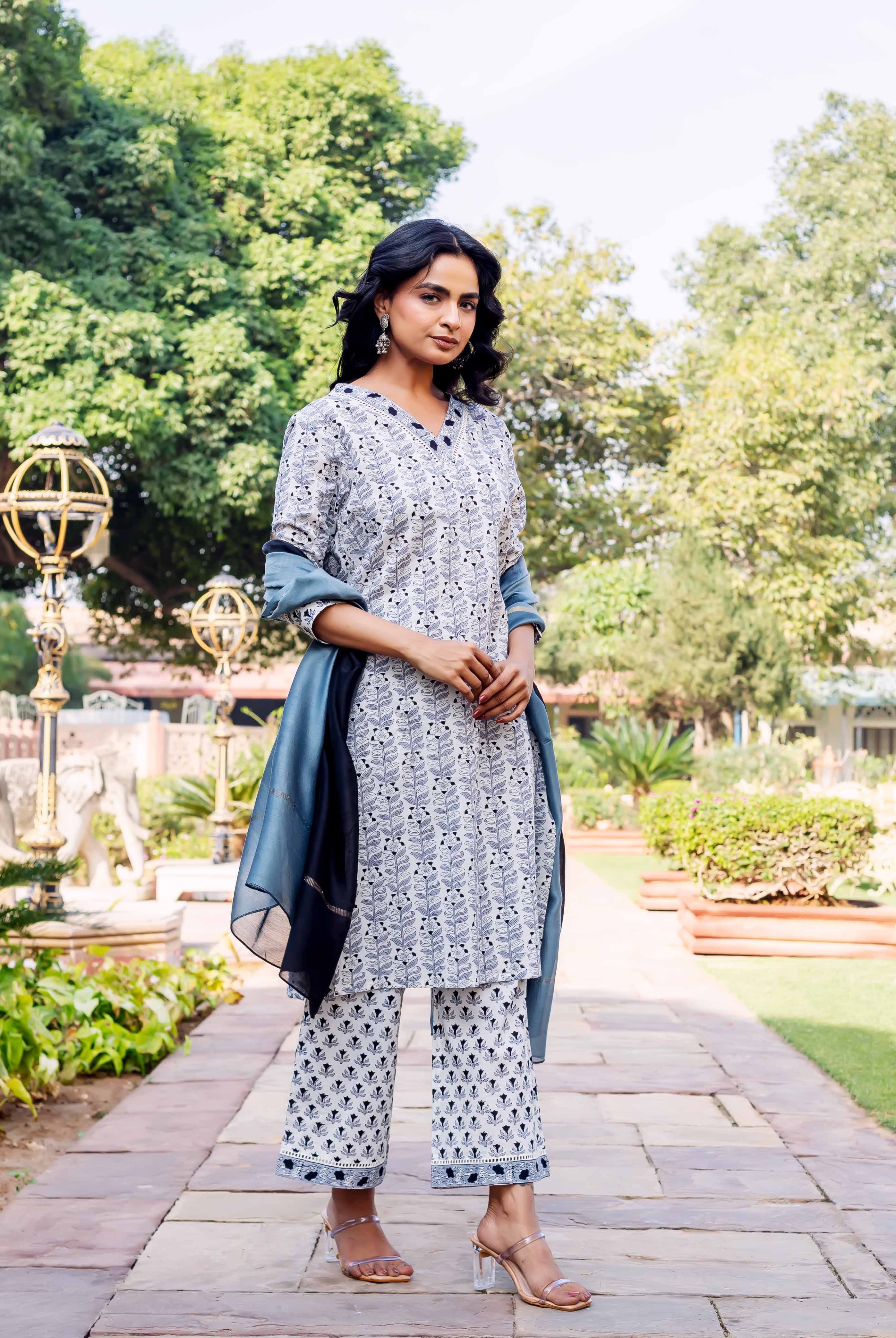 Full look of model in white and blue block-printed leafy cotton kurta set with dupatta.
