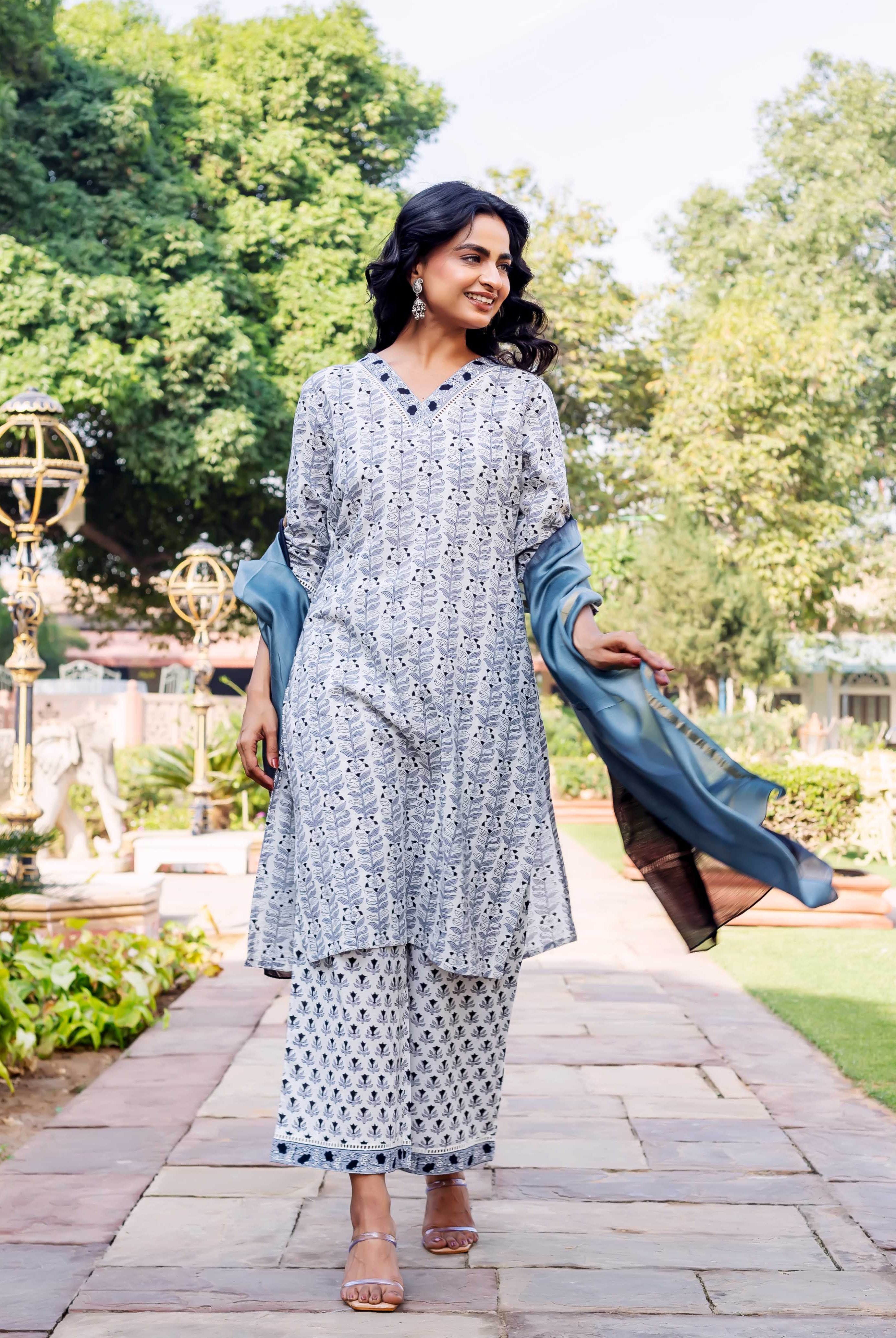 Model wearing a hand-block-printed blue and white cotton kurta set with blue dupatta.