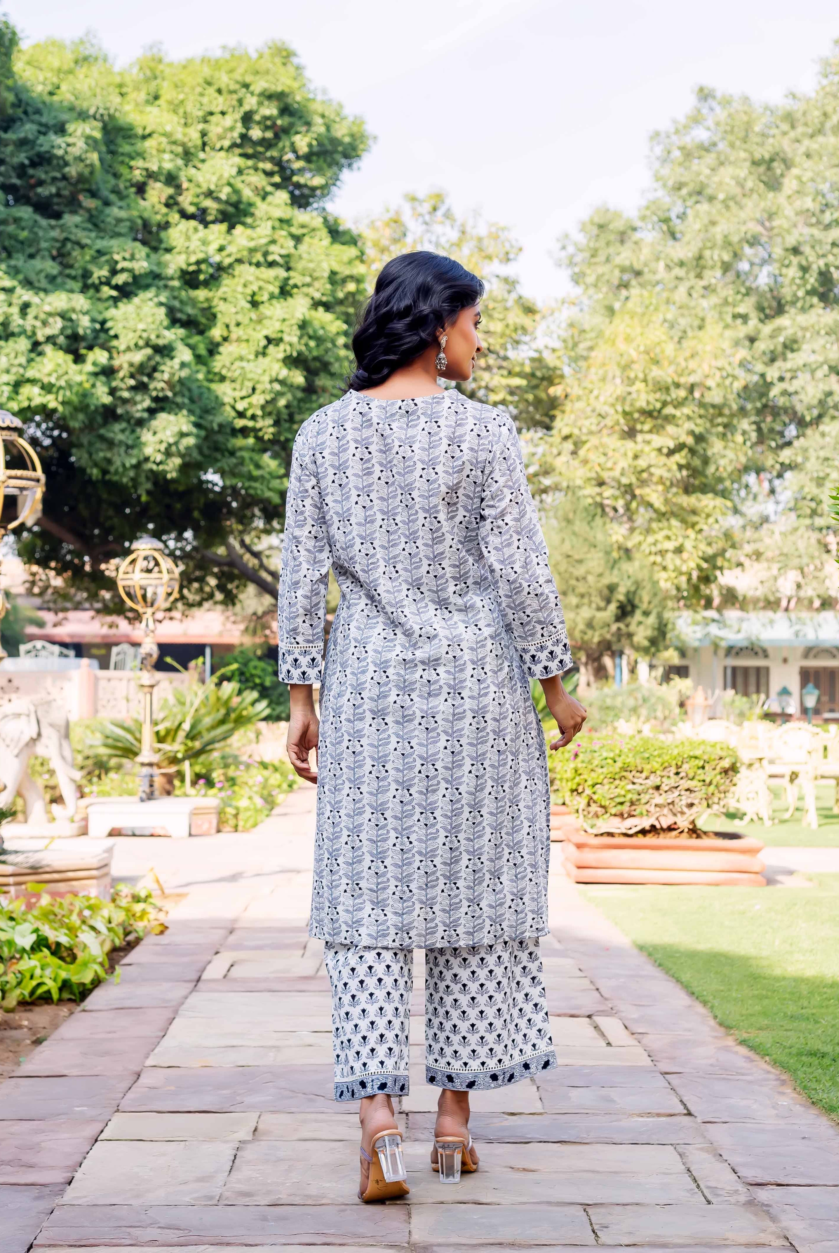 Back view of model in white and grey block printed leafy kurta and patterned pants.