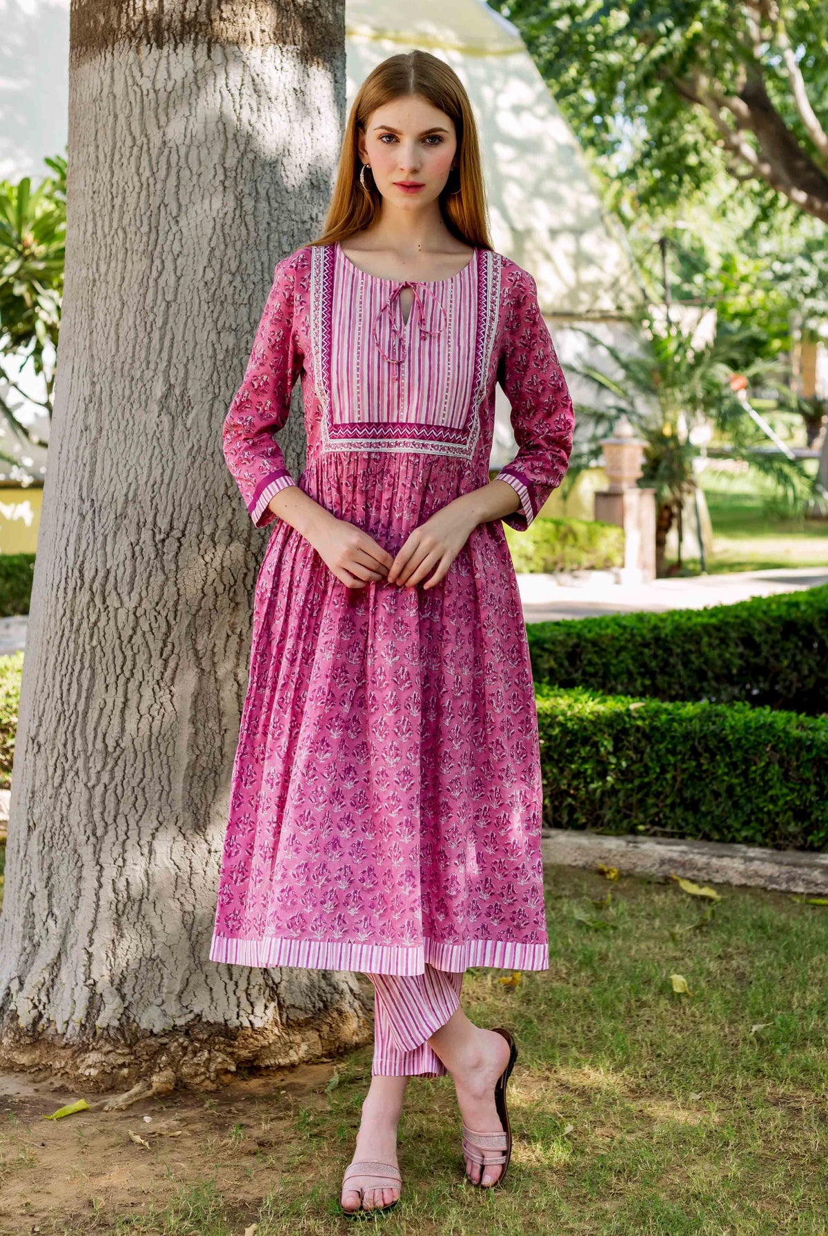 A model wearing a pink, hand-block-printed A-line kurta with a floral pattern.