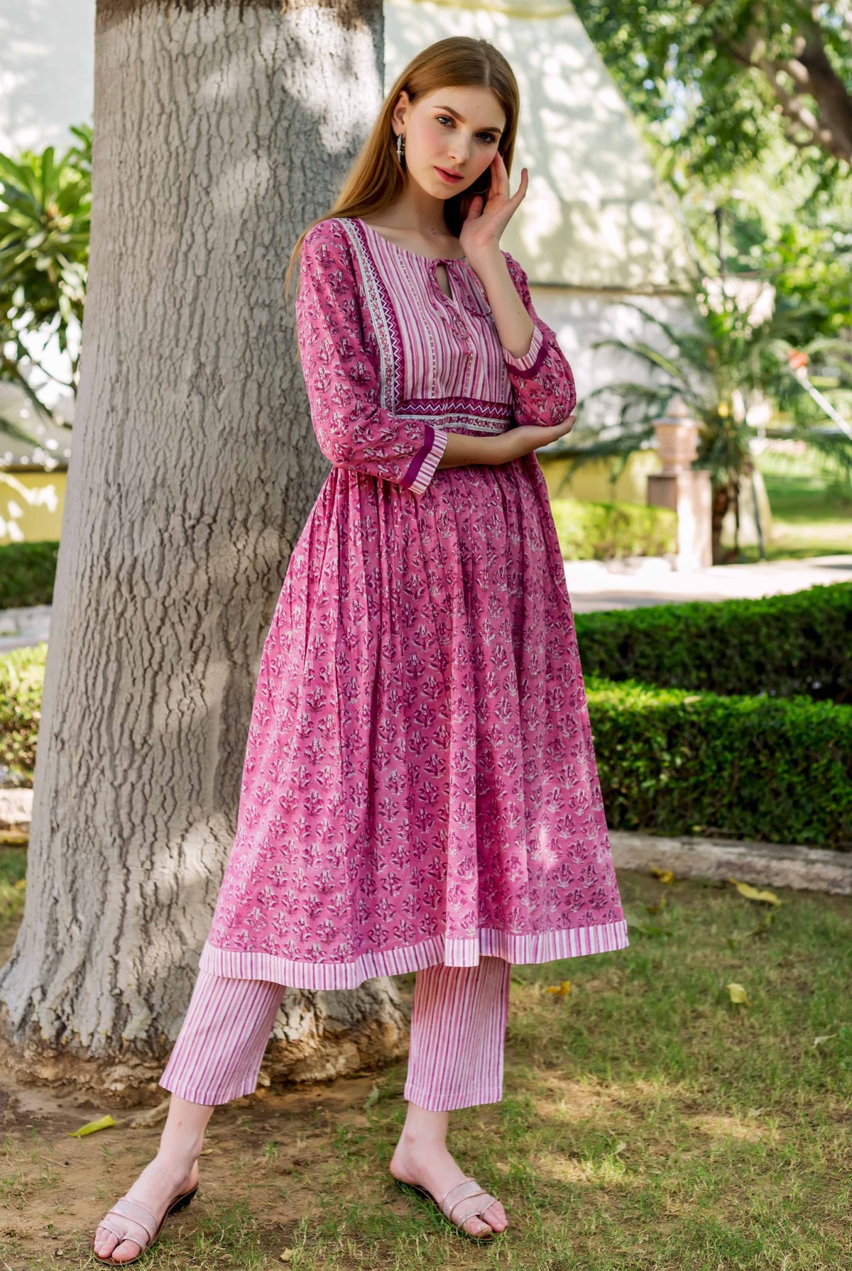 Model in a pink A-line hand-block printed ethnic cotton kurta with striped yoke and pants.