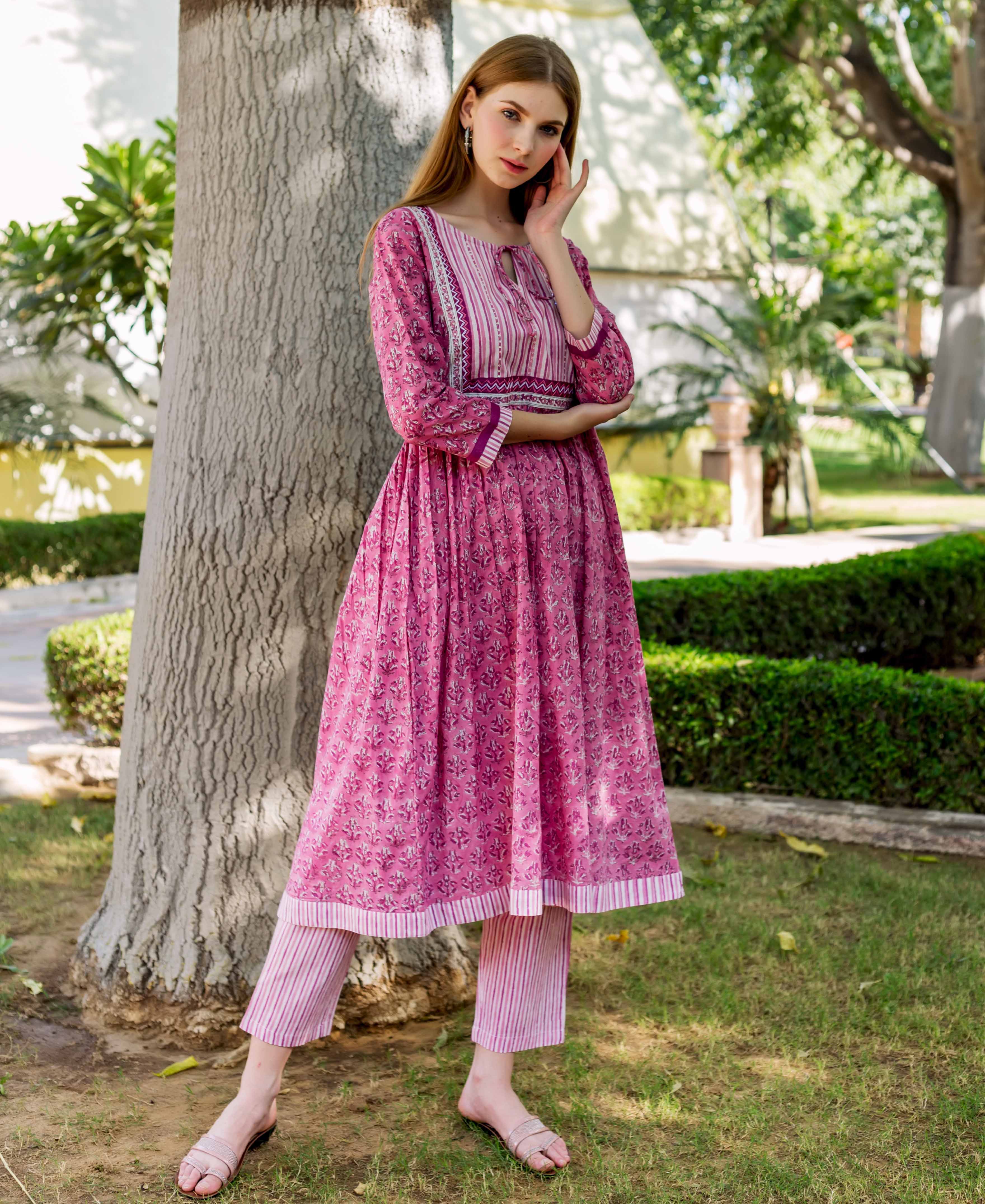 Model in a pink A-line hand-block printed ethnic cotton kurta with striped yoke and pants.
